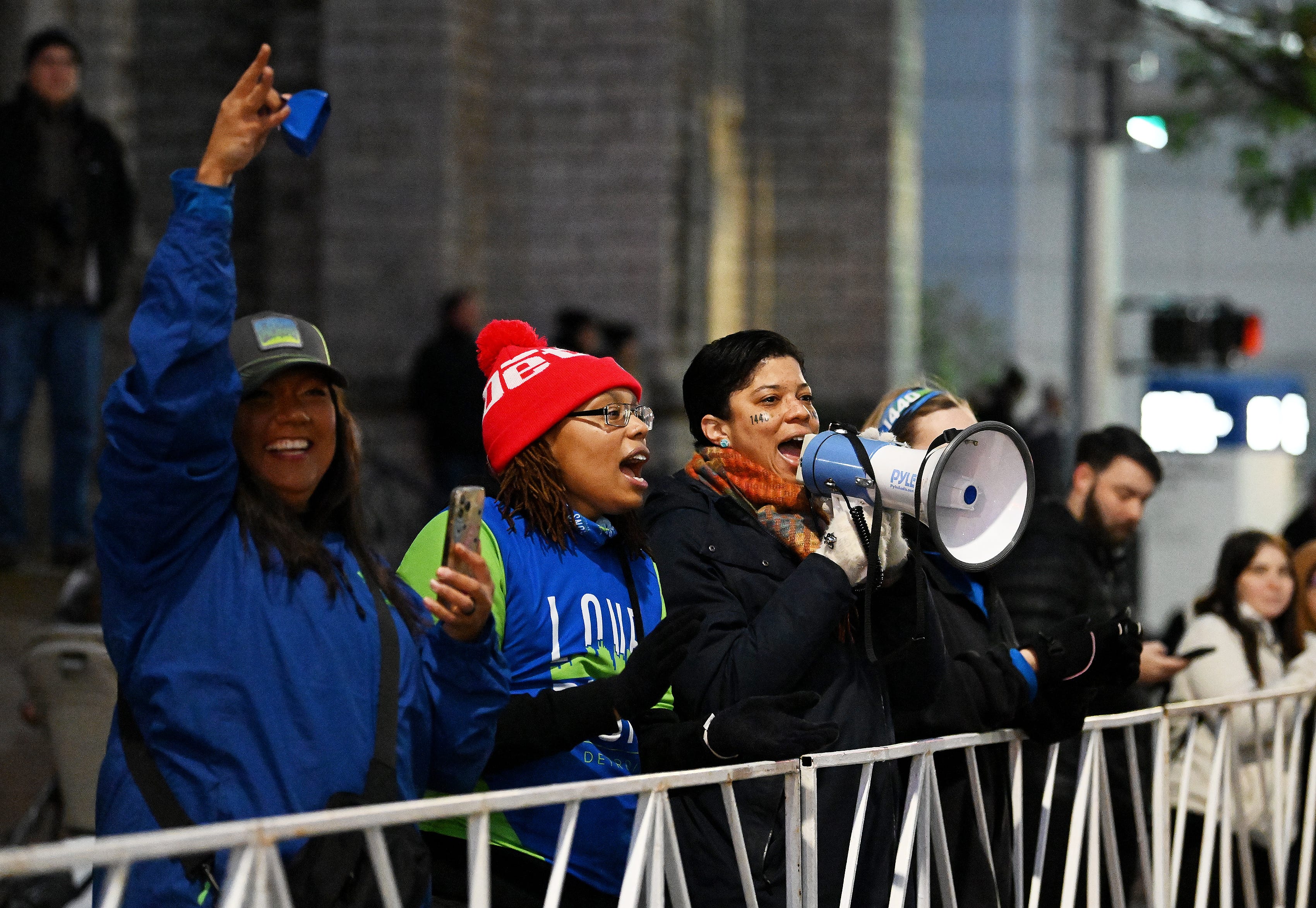 Veronica Coker, left, Micah Johnson, 34, of Detroit and Rebecca Hason, 44, of Saline from the Love Runs organization cheer on the runners at the start of the Detroit Free Press Marathon in Detroit on Oct. 15, 2023.