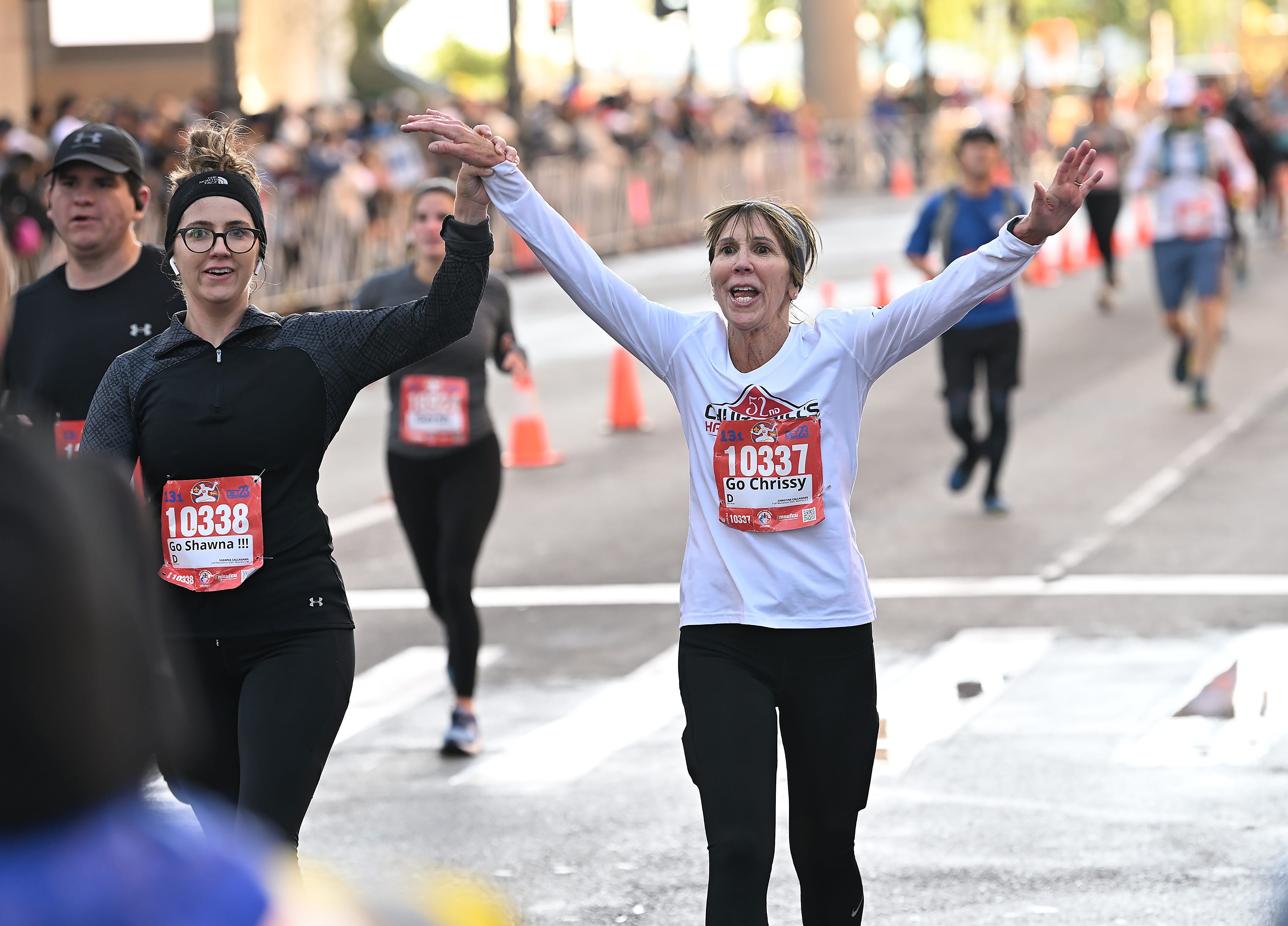 From left, Shawna Callighan and Christine Callighan both of Toledo finish the half marathon at the Detroit Free Press Marathon in Detroit on Oct. 15, 2023.
