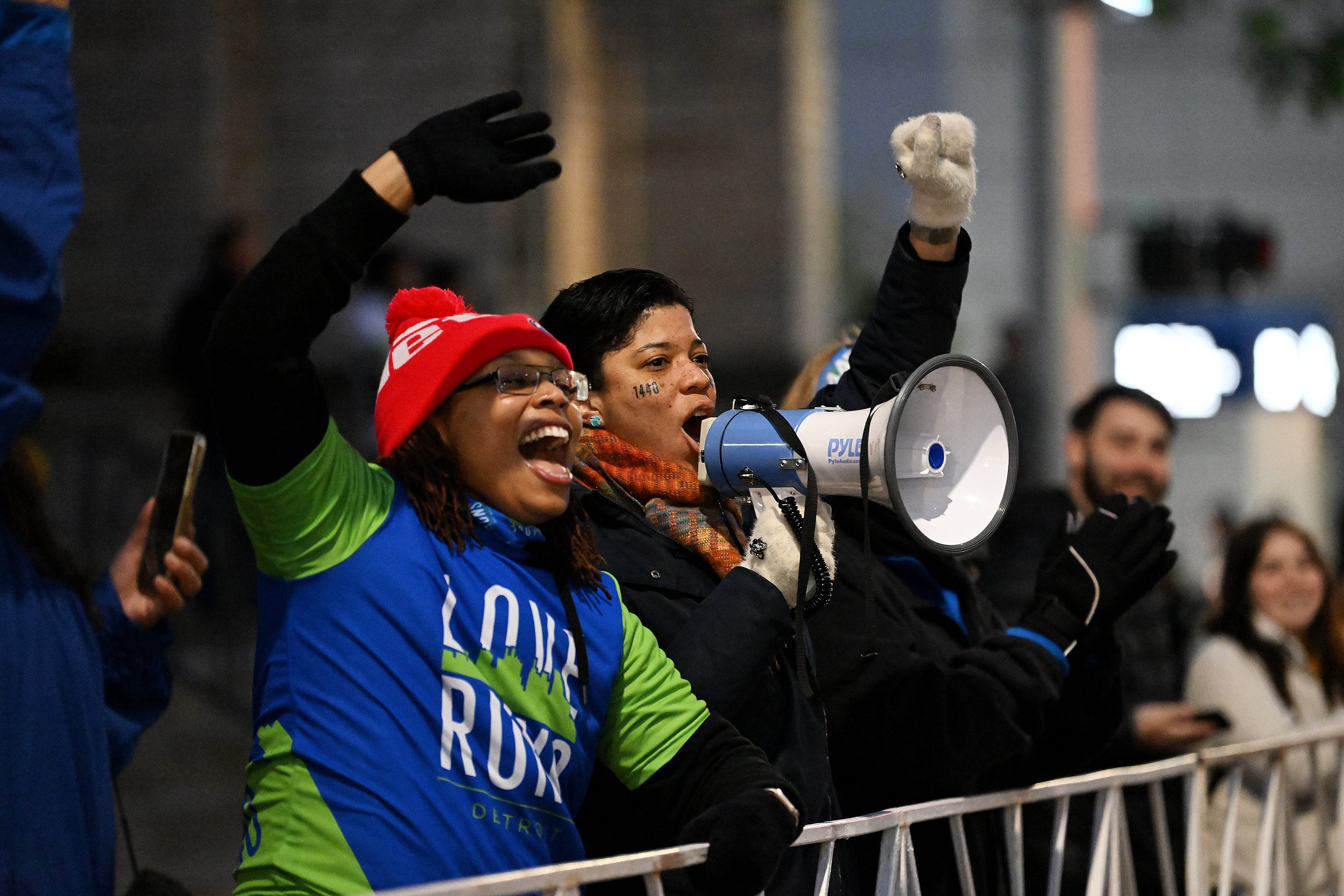 From left, Micah Johnson, 34, of Detroit and Rebecca Hason, 44, of Saline from the Love Runs organization cheer on the runners at the start of the Detroit Free Press Marathon in Detroit on Oct. 15, 2023.