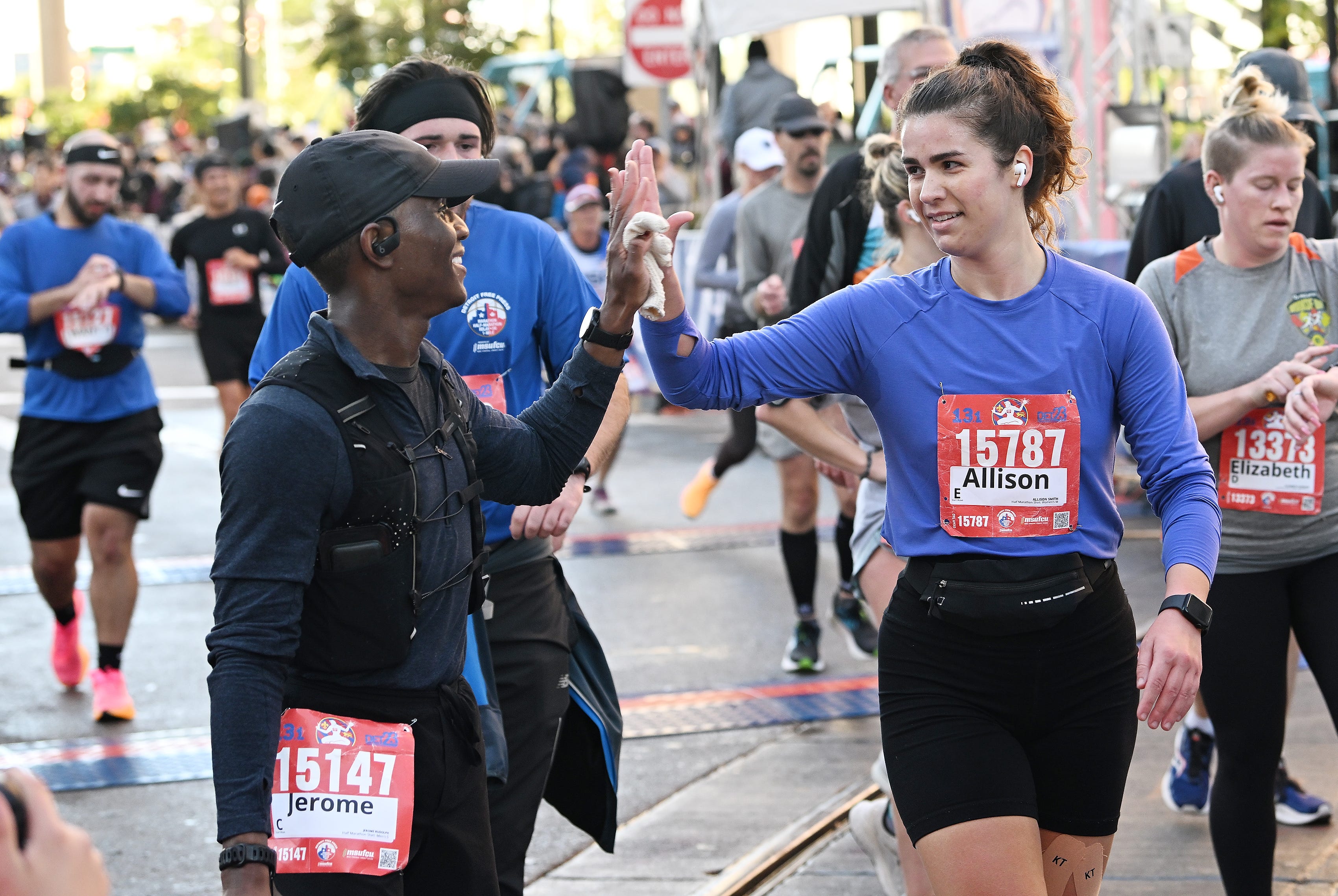 From left, Jerome Rudolph, 23, of Detroit and Allison Smith, 23, of Swartz Creek react as they finish the half marathon.