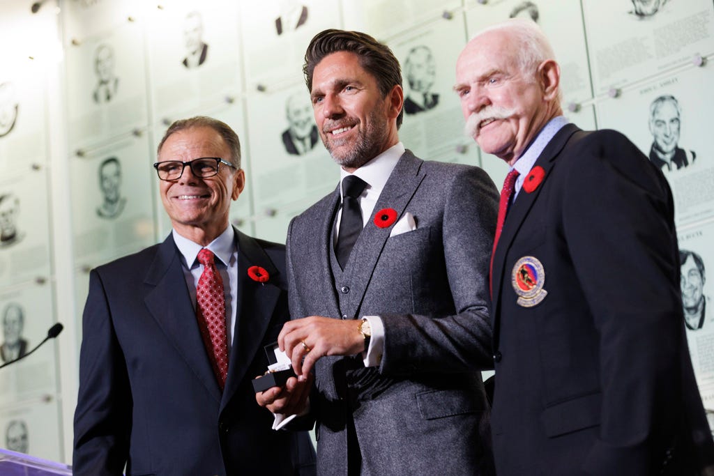 Hockey Hall of Fame inductee Henrik Lundqvist, center, receives his Hockey Hall of Fame ring from Mike Gartner, left, and Lanny McDonald as he's inducted into the Hall in Toronto on Friday.