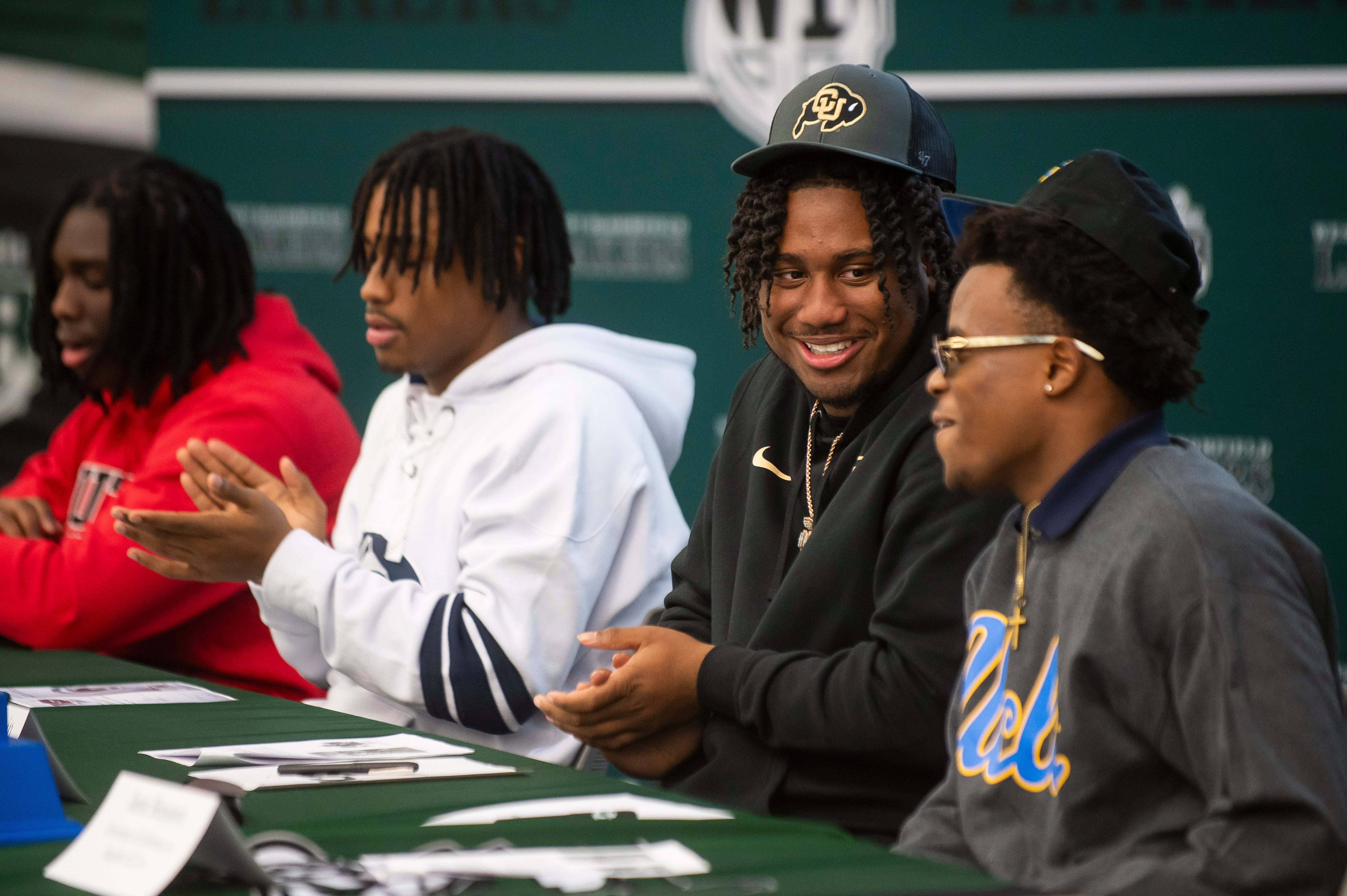 From left, West Bloomfield High School varsiy football players Montele Johnson II, Kari Jackson, Brandon Davis Swain and Jamir Benjamin applaud during a ceremony celebrating each of them signing letters of intent to play football at four different universities on Wednesday.