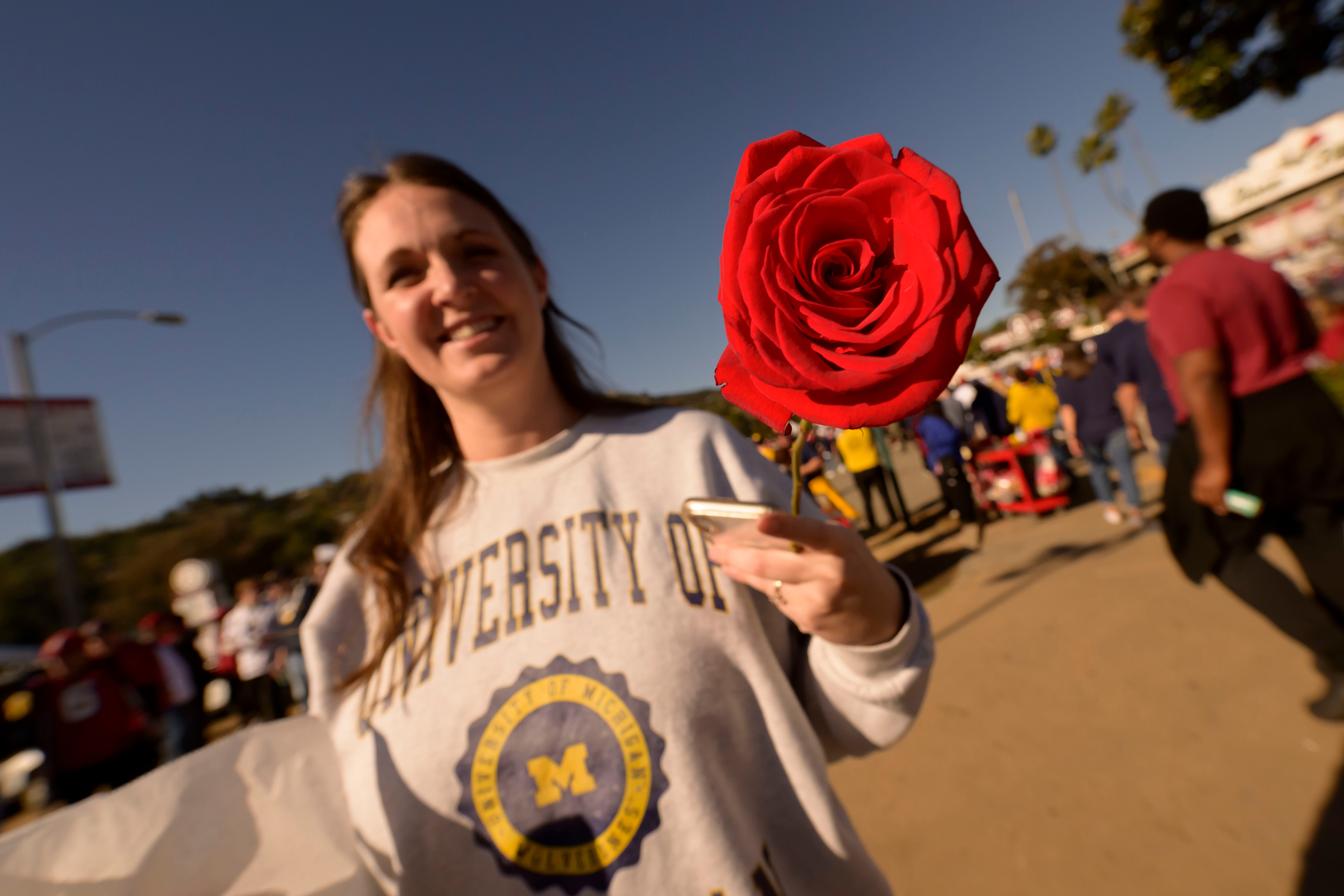 Holly Dubinsky, of Ada, walks around outside the stadium with a rose before the start of the Rose Bowl, in Pasadena, California on Jan. 1, 2024.