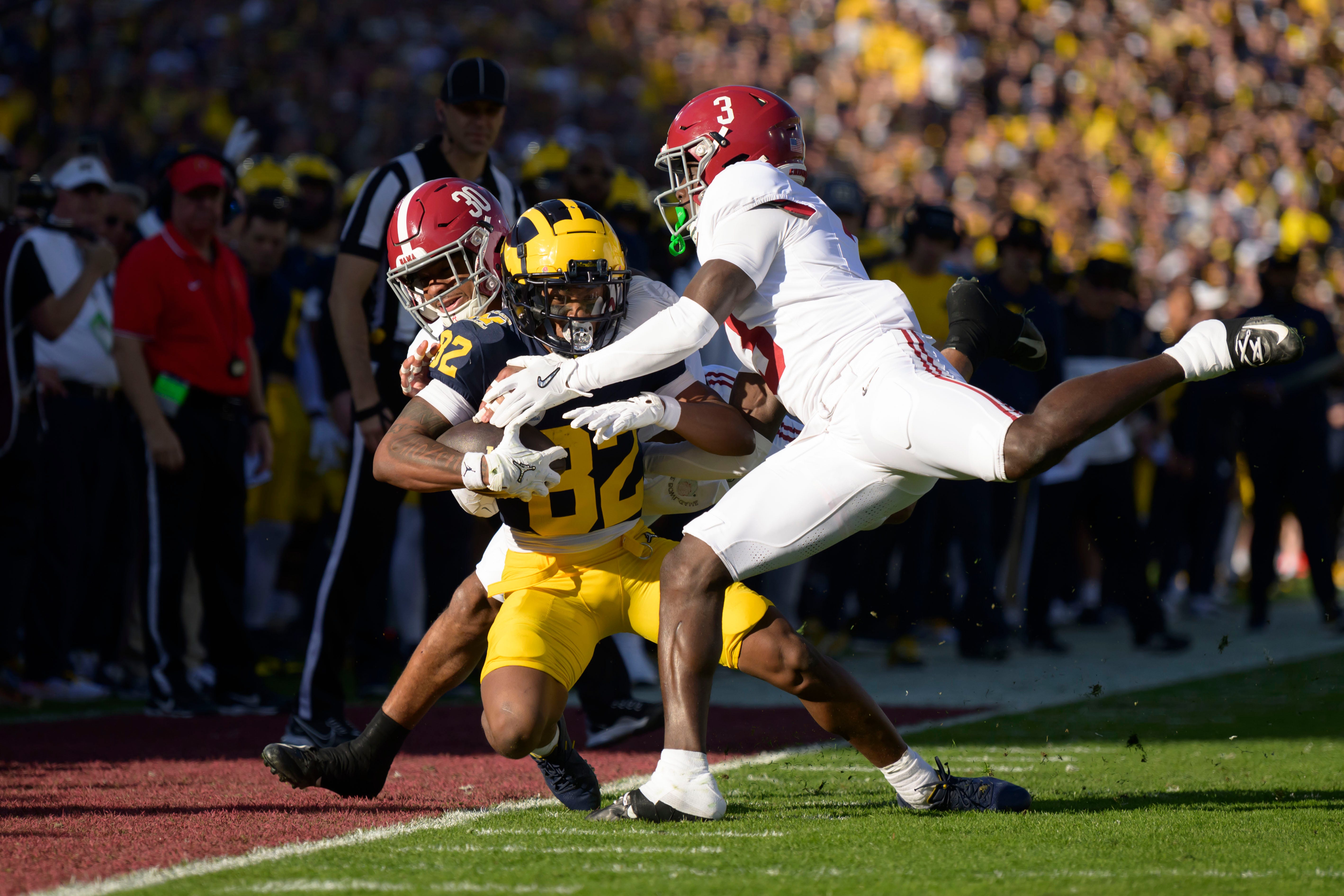 Michigan wide receiver Semaj Morgan is tackled by Alabama linebacker Jihaad Campbell, left, and defensive back Terrion Arnold during the first quarter of the Rose Bowl, in Pasadena, California, January 1, 2024.