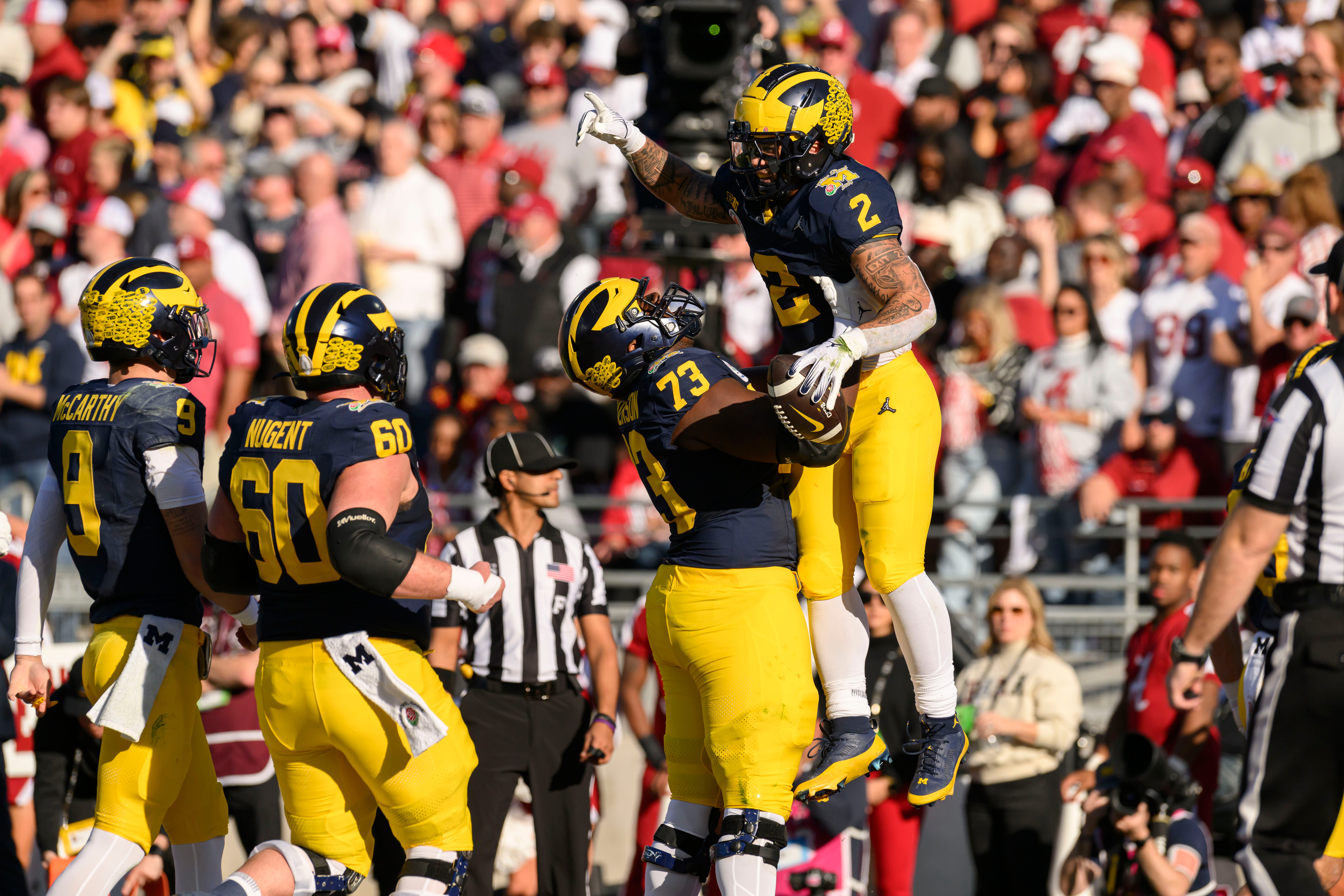 Michigan running back Blake Corum is lifted into the air by offensive lineman LaDarius Henderson after scoring a touchdown during the first quarter of the Rose Bowl, in Pasadena, California, January 1, 2024.