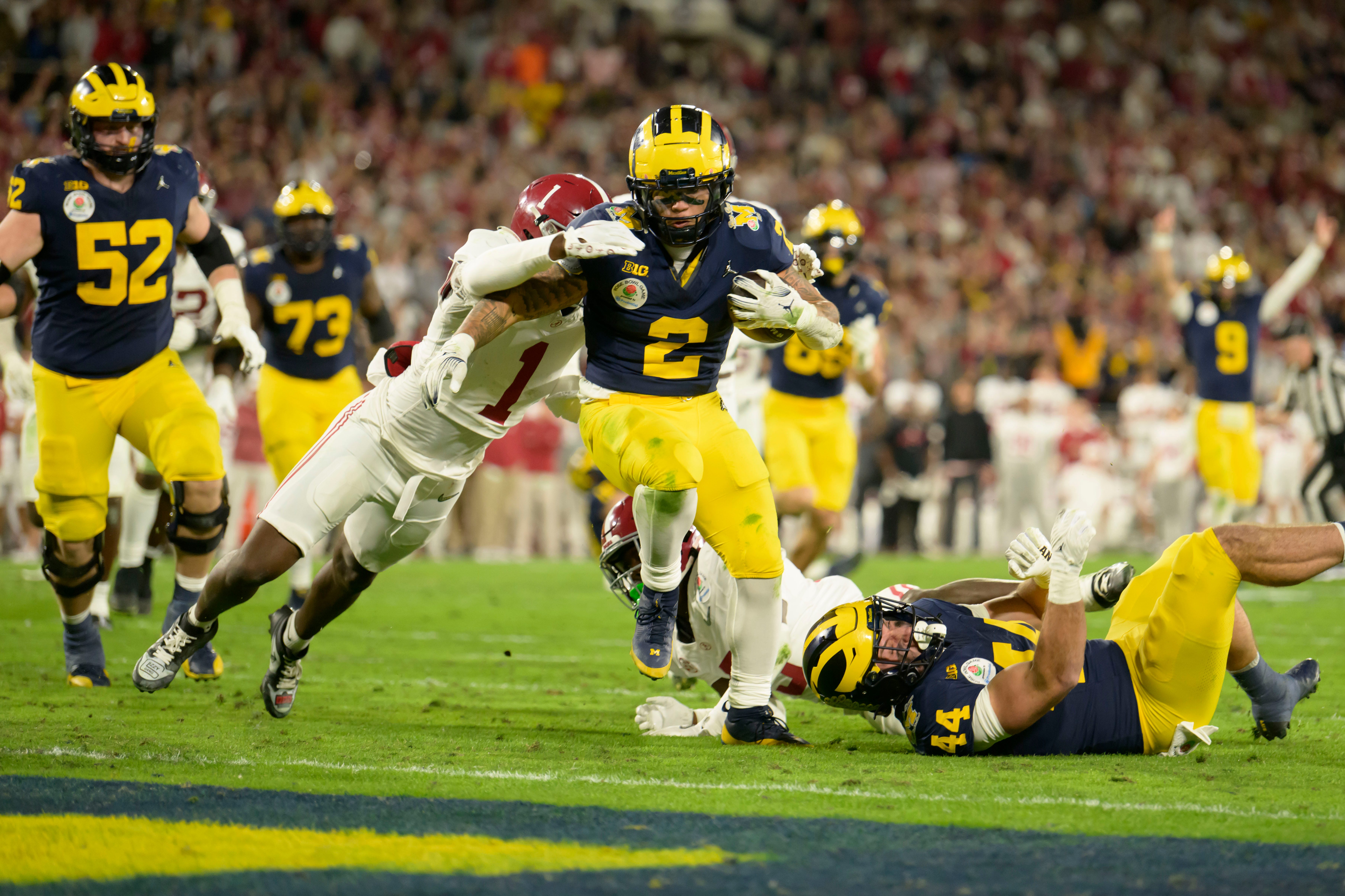 Michigan running back Blake Corum shakes off a tackle by Alabama defensive back Kool-Aid McKinstry to score the game winning touchdown during the overtime period of the Rose Bowl, in Pasadena, California, January 1, 2024.