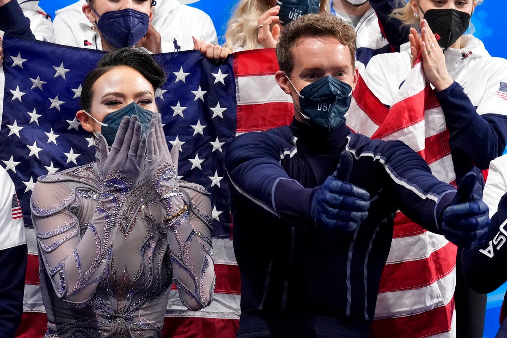 Madison Chock and Evan Bate react after the team ice dance program during the figure skating competition at the 2022 Winter Olympics in Beijing.