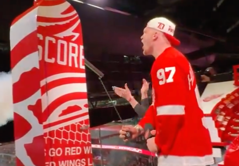 Lions defensive end Aidan Hutchinson fires up the Red Wings' crowd before Tuesday's game against the Capitals at Little Caesars Arena.