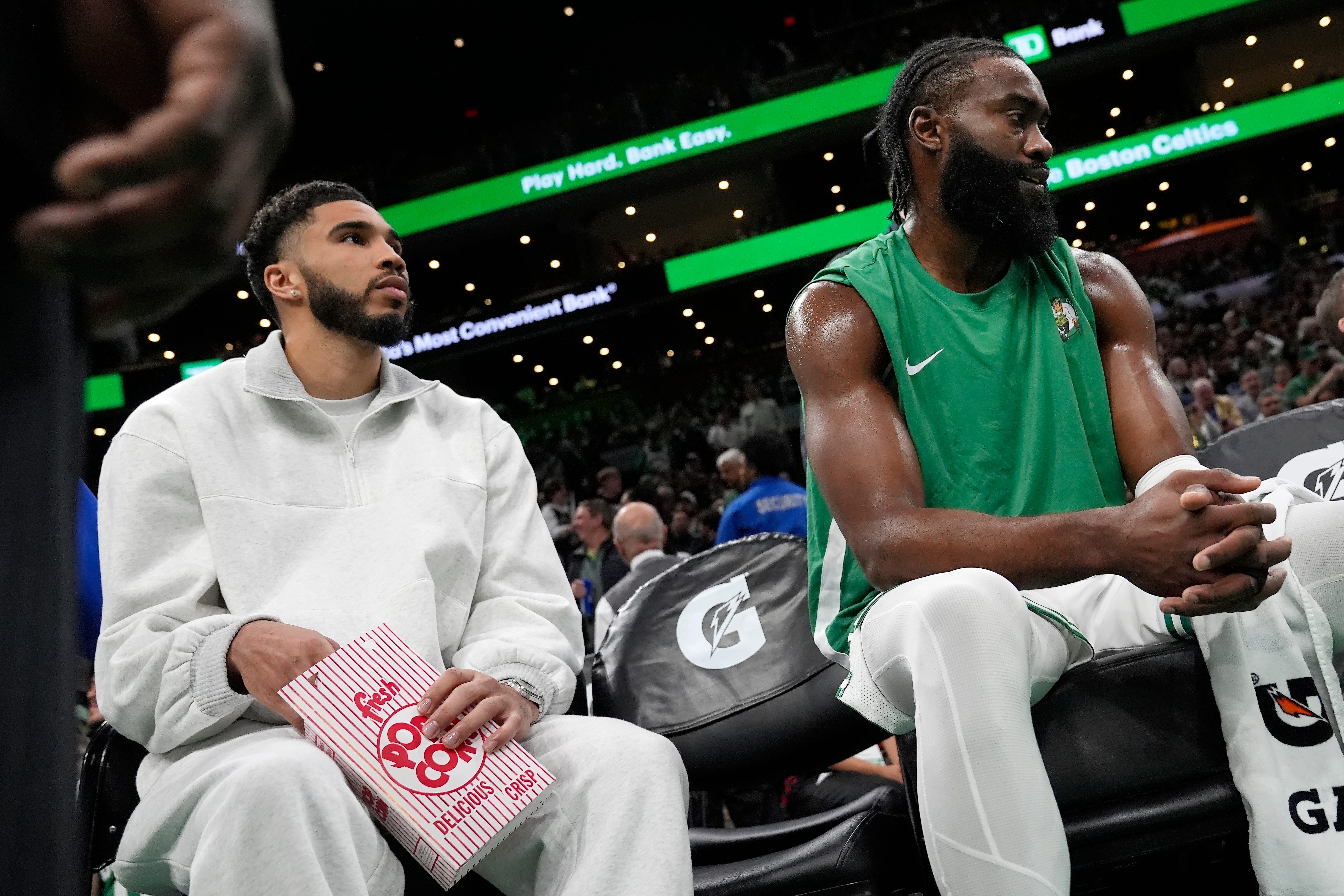 Boston Celtics' Jayson Tatum, left, sits on the bench with teammate Jaylen Brown, right, during the first half.