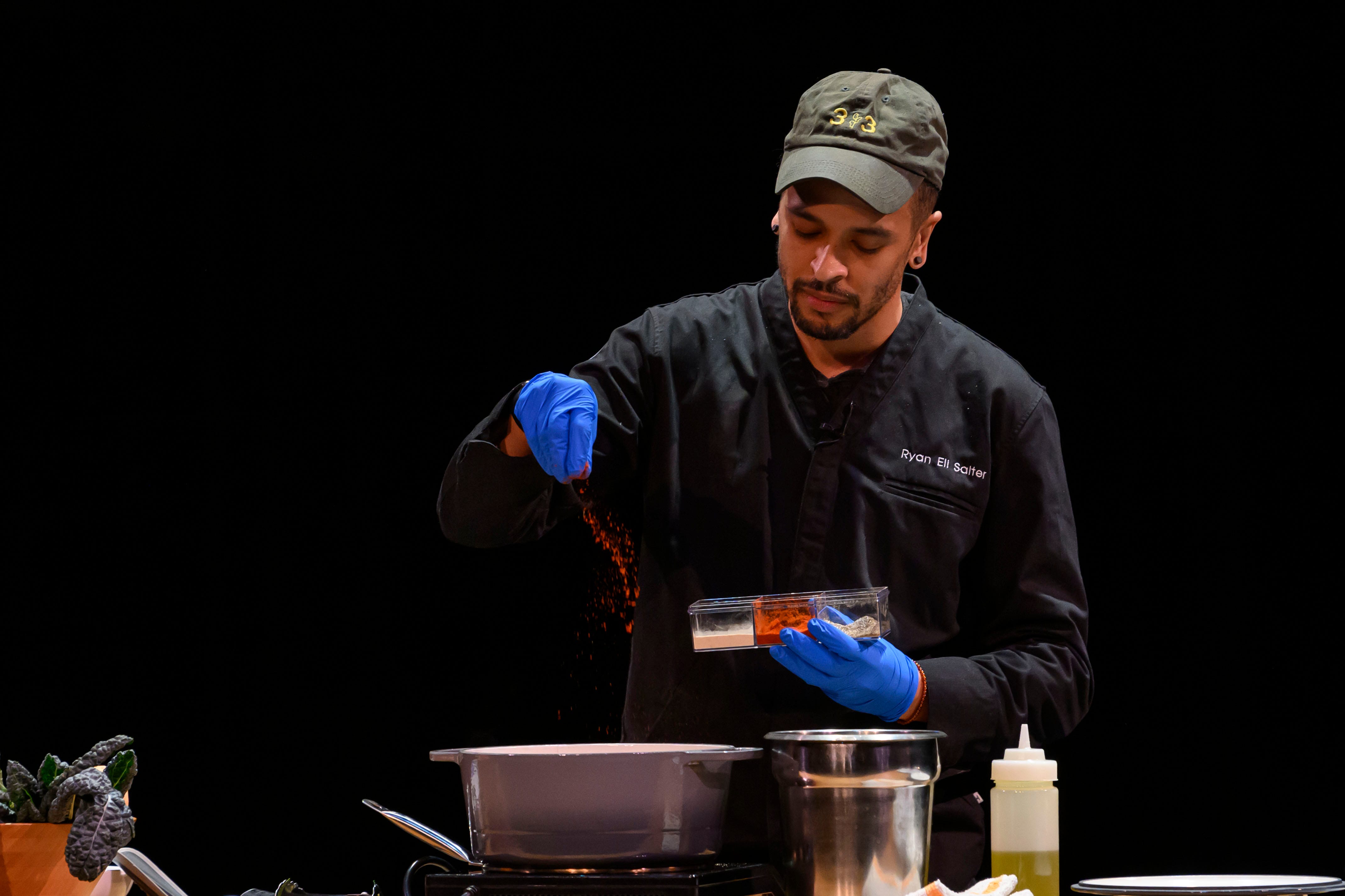 Chef Ryan Salter from Breadless demonstrates how to make a sweet potato, squash, and braised greens bowl during the event series Dish and Design, at the Berman Center for Performing Arts, in West Bloomfield, March 20, 2024.