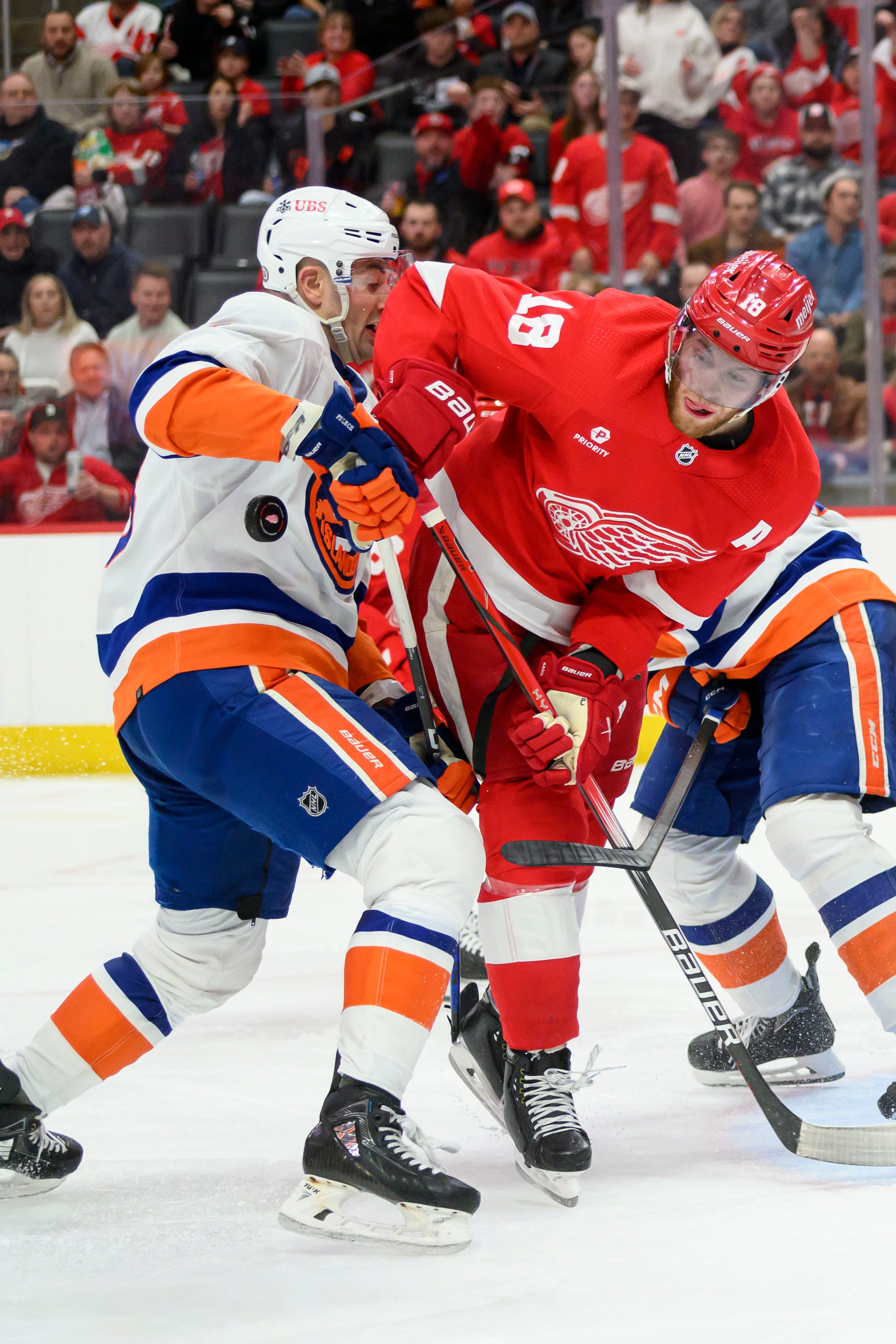 Detroit Red Wings center Andrew Copp and New York defenseman Adam Pelech battle for the puck during the third period.