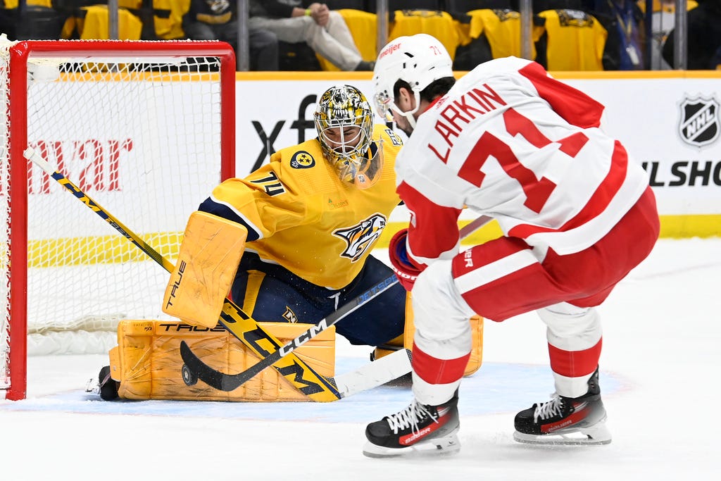 Predators goaltender Juuse Saros (74) stops a shot by Red Wings center Dylan Larkin (71) during the first period of Saturday's game in Nashville, Tenn.