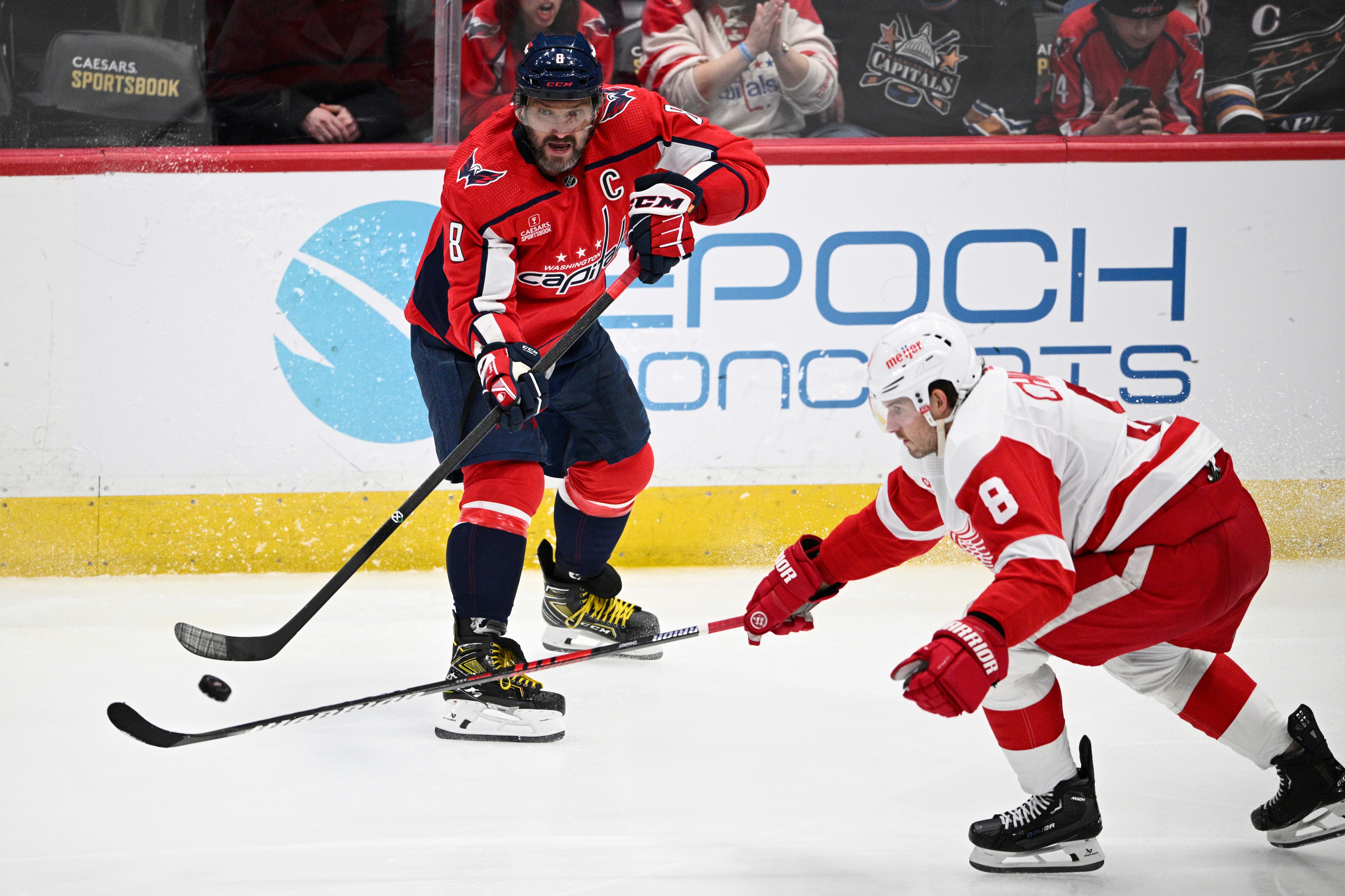Washington Capitals left wing Alex Ovechkin, top, passes the puck against Detroit Red Wings defenseman Ben Chiarot, bottom, during the third period.
