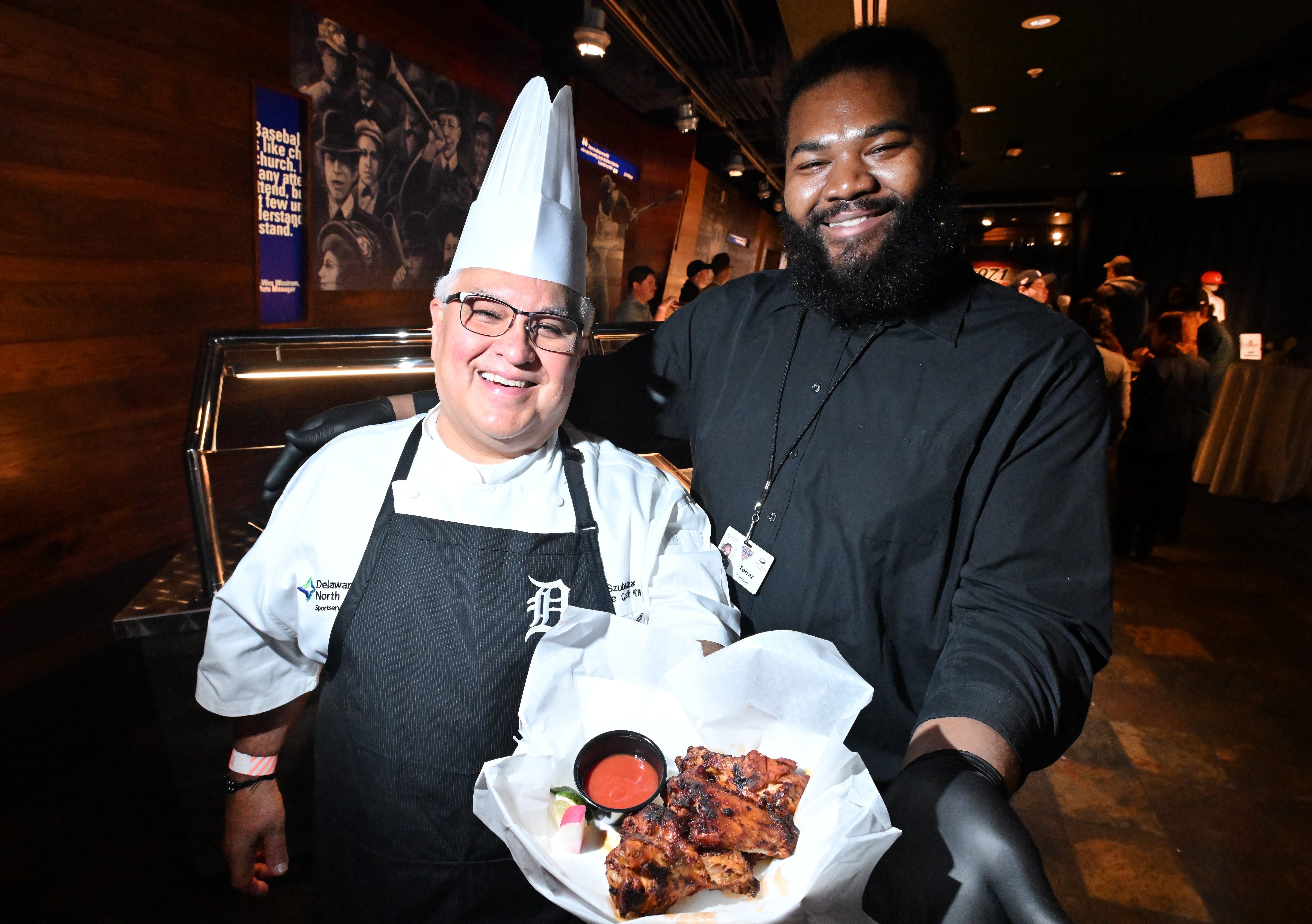 Delaware North Sports Service Chef Mark Szubeczak and Torrez Parker with the charcoal grilled chicken wings during the Tigers "what's new" event at Comerica Park for the 2024 season.