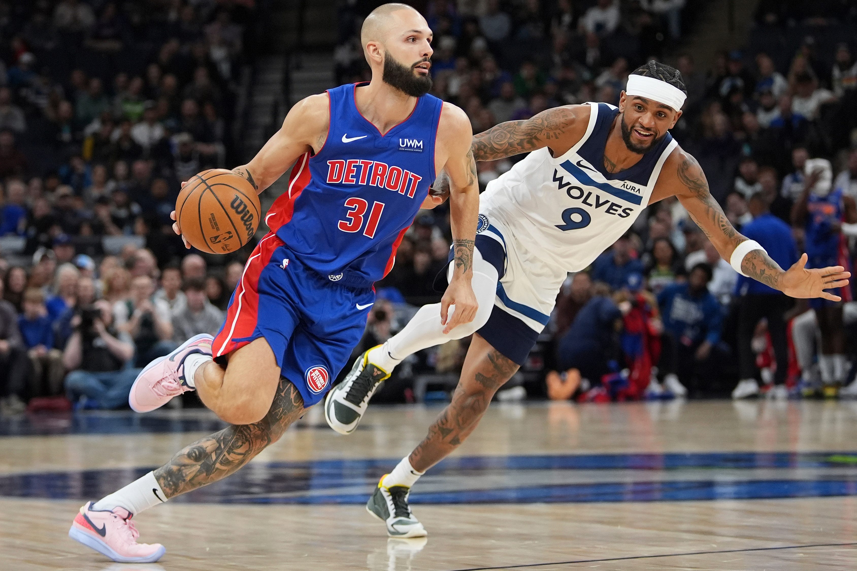 Detroit Pistons guard Evan Fournier (31) works toward the basket as Minnesota Timberwolves guard Nickeil Alexander-Walker (9) defends during the first half of an NBA basketball game, Wednesday, March 27, 2024, in Minneapolis.