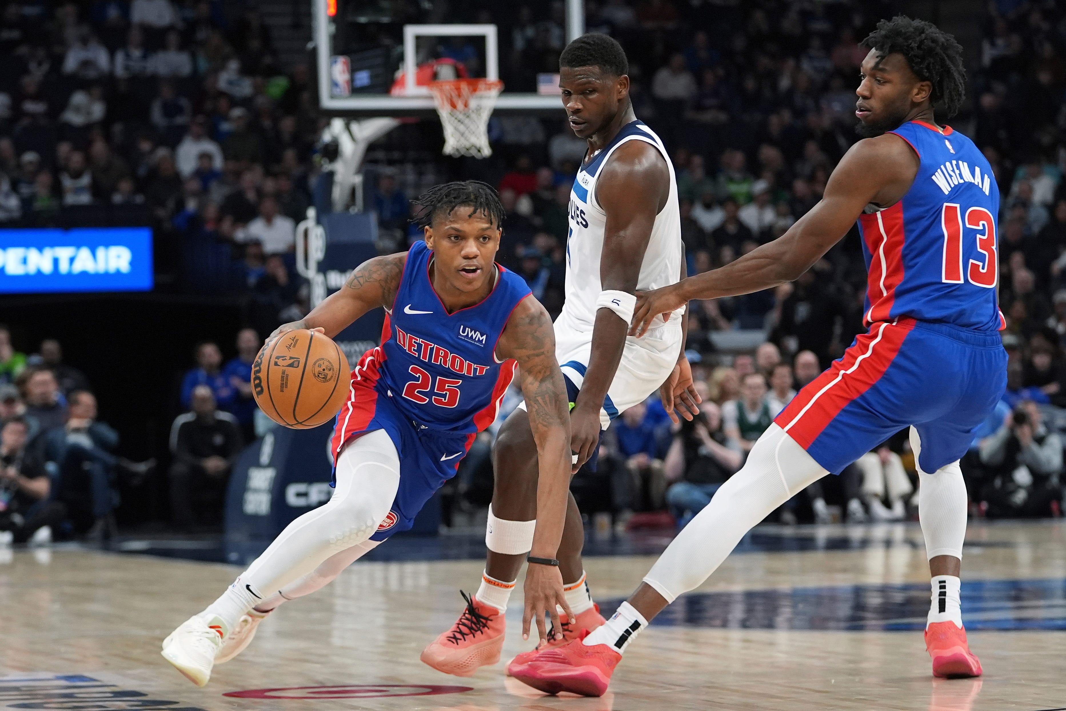 Detroit Pistons guard Marcus Sasser (25) works toward the basket as Minnesota Timberwolves guard Anthony Edwards, center, defends during the first half.