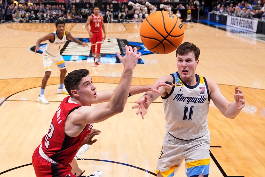 North Carolina State's Michael O'Connell, left, and Marquette's Tyler Kolek (11) compete for a rebound during the second half of a Sweet 16 college basketball game on Friday in the NCAA Tournament in Dallas.