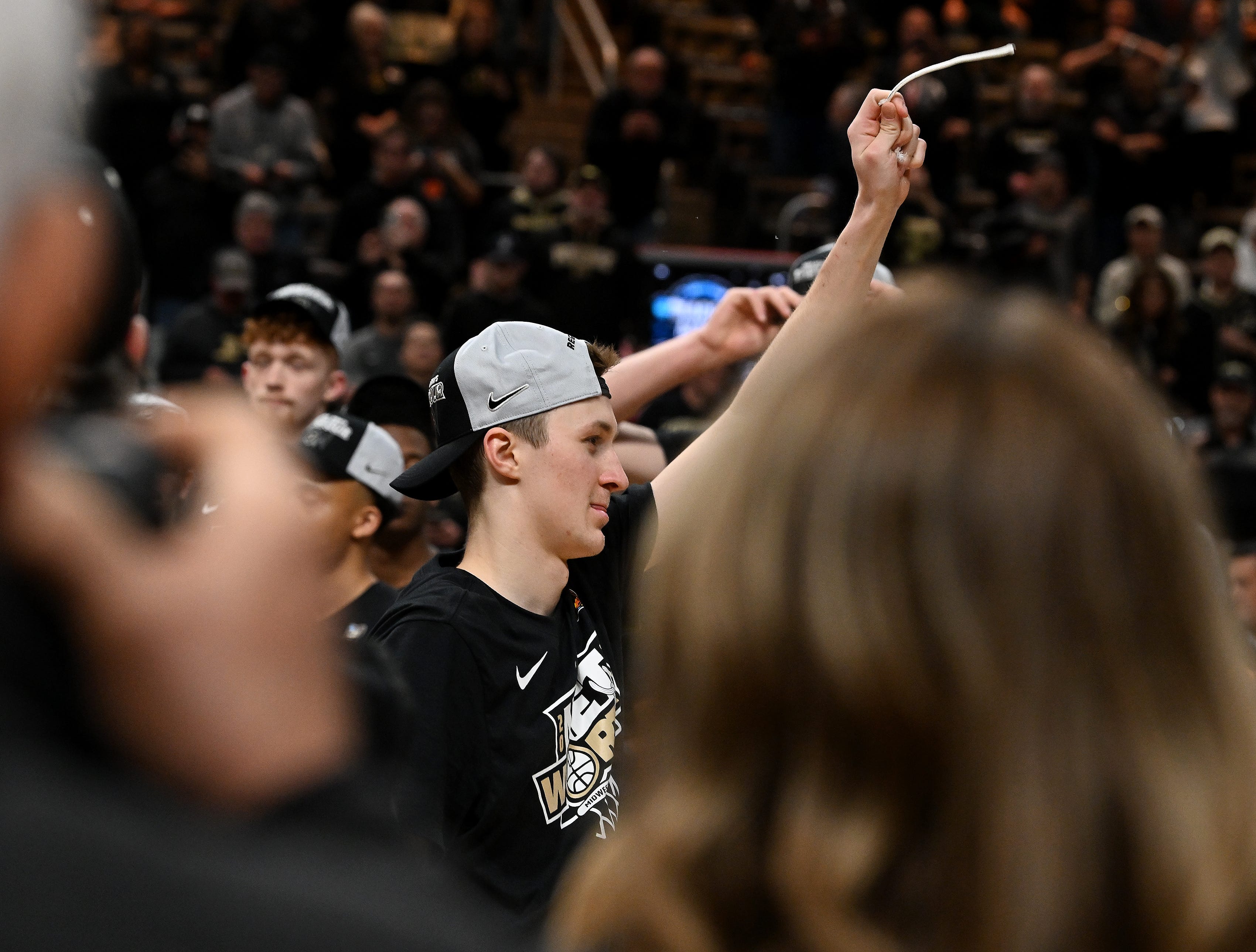 Purdue guard Fletcher Loyer (2) holds up a piece of the net after the game.