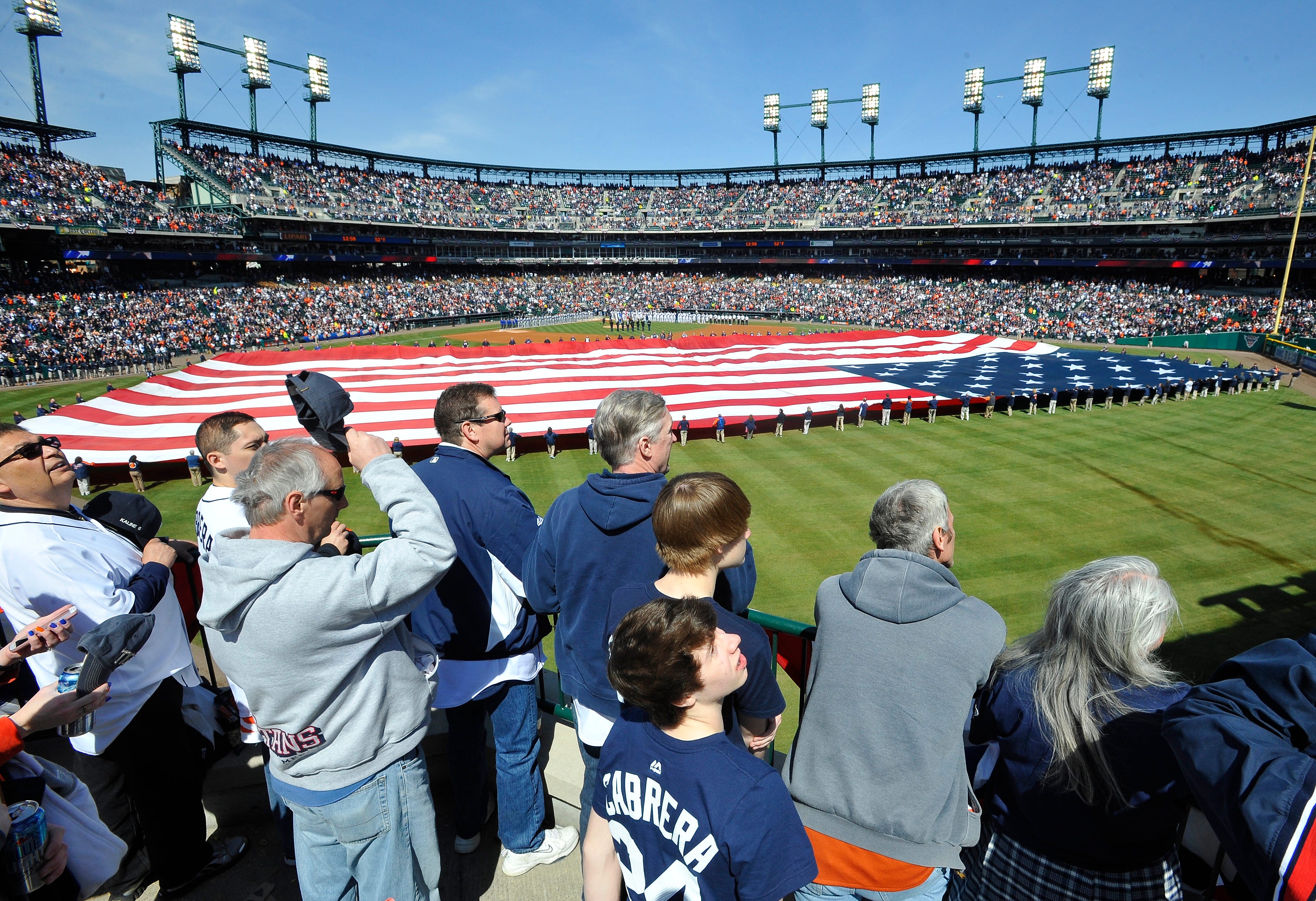 People stand for the National Anthem at the Detroit Tigers Opening Day vs the Kansas City Royal at Comerica Park in Detroit, Michigan on March 31, 2014.