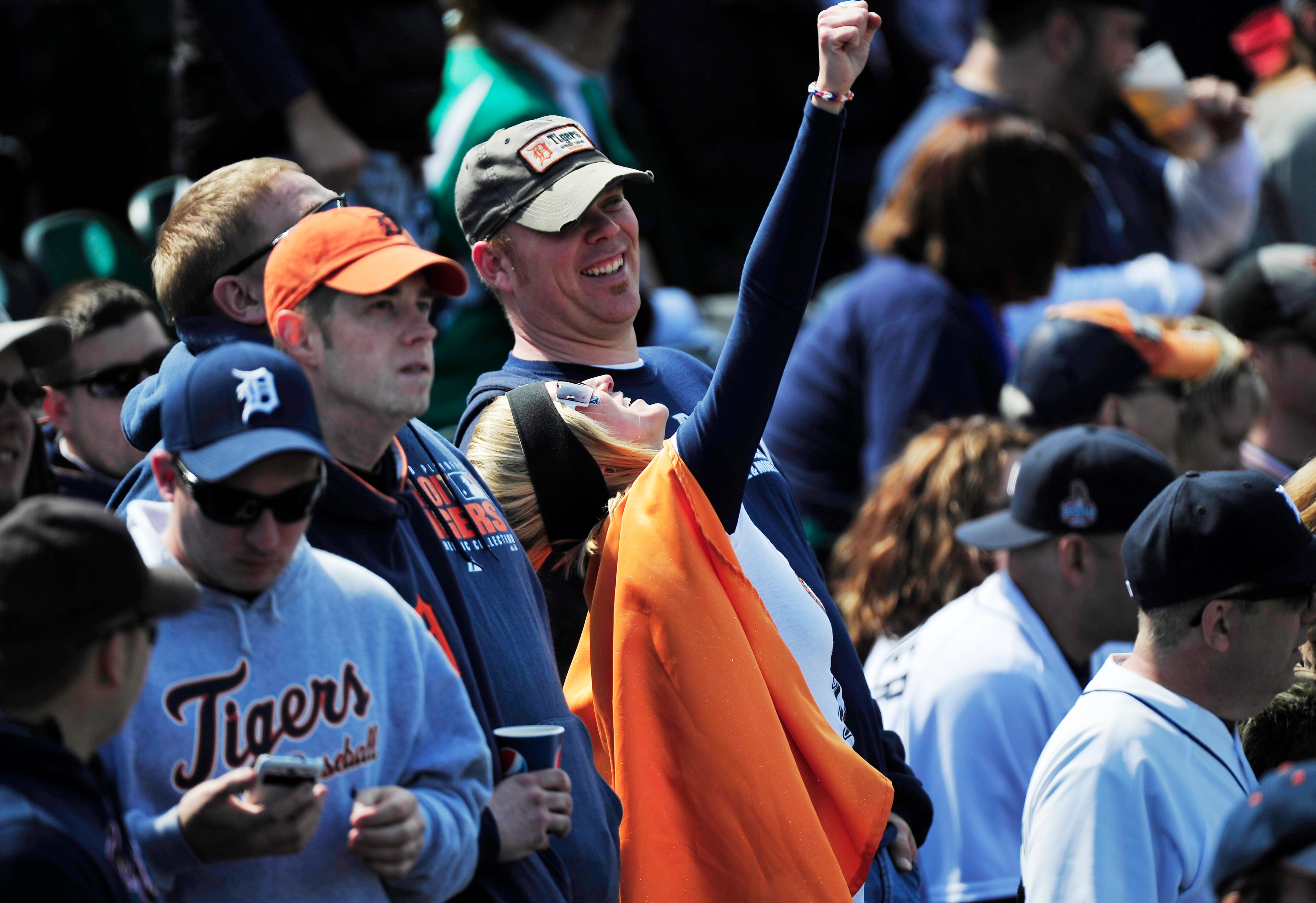 A super Tigers fans enjoying the sun, the Tigers victory or both, throws a fist into the air on the Detroit Tigers season opening at Comerica Park. nning. Detroit Tigers Opening Day vs the Kansas City Royal at Comerica Park in Detroit, Michigan on March 31, 2014.