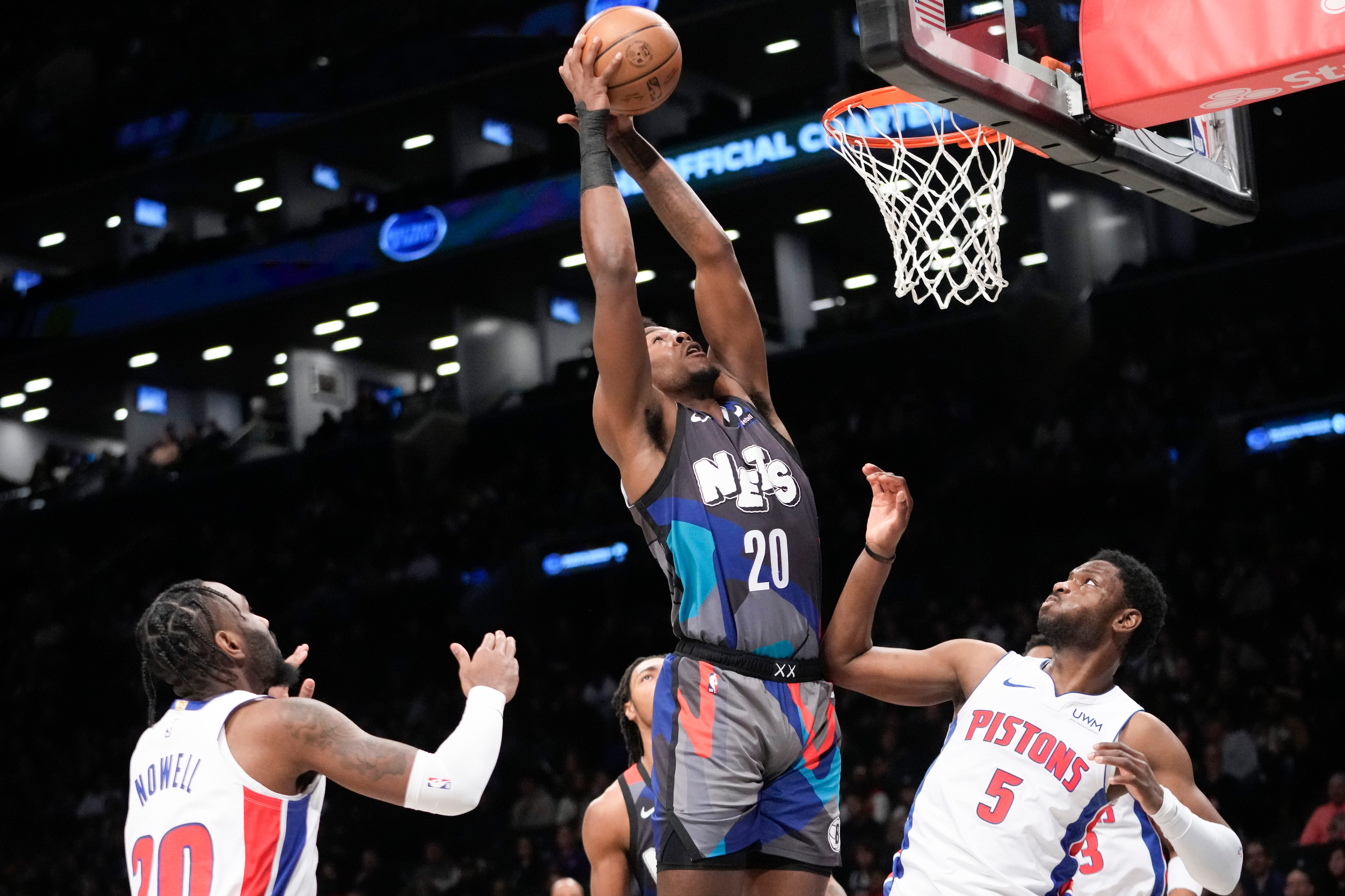 Brooklyn Nets center Day'Ron Sharpe (20) goes to the basket against Detroit Pistons guards Jaylen Nowell (5) and Jaylen Nowell, left, during the first half.