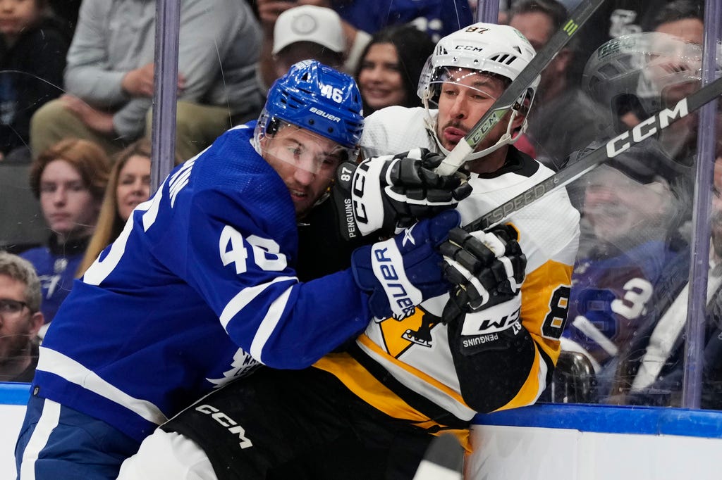 Maple Leafs' Ilya Lyubushkin (46) checks Penguins' Sidney Crosby (87) during first-period NHL hockey game action in Toronto on Monday.