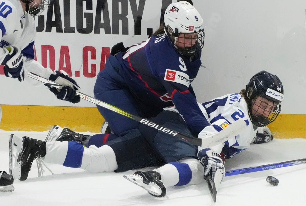 Plymouth's Kirsten Simms (9) and Finland's Viivi Vainikka (24) battle for the puck during the first period in the semifinals of the women's world hockey championships on Saturday in Utica, N.Y.