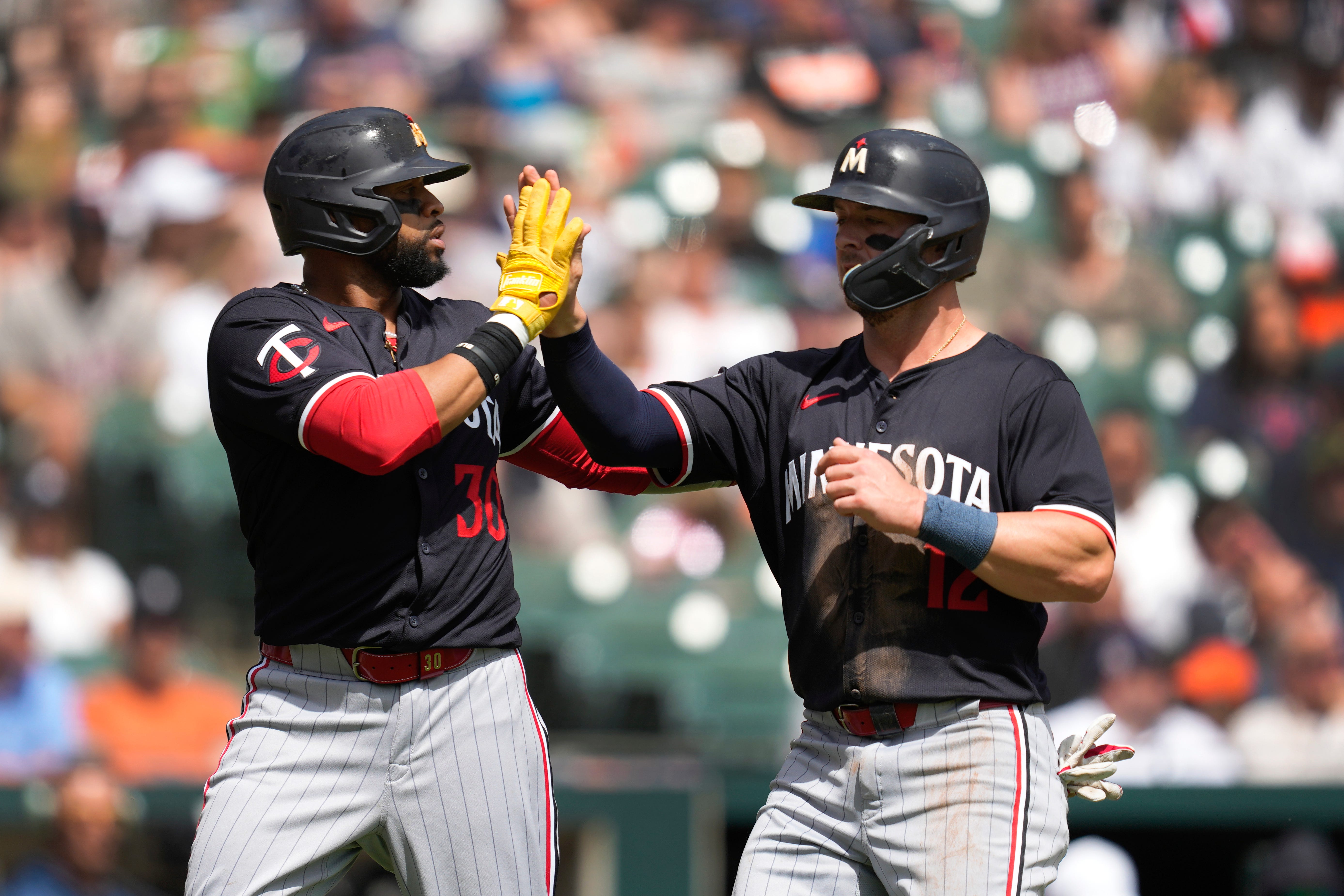 The Twins' Carlos Santana (30) and Kyle Farmer (12) celebrate scoring in the second inning.