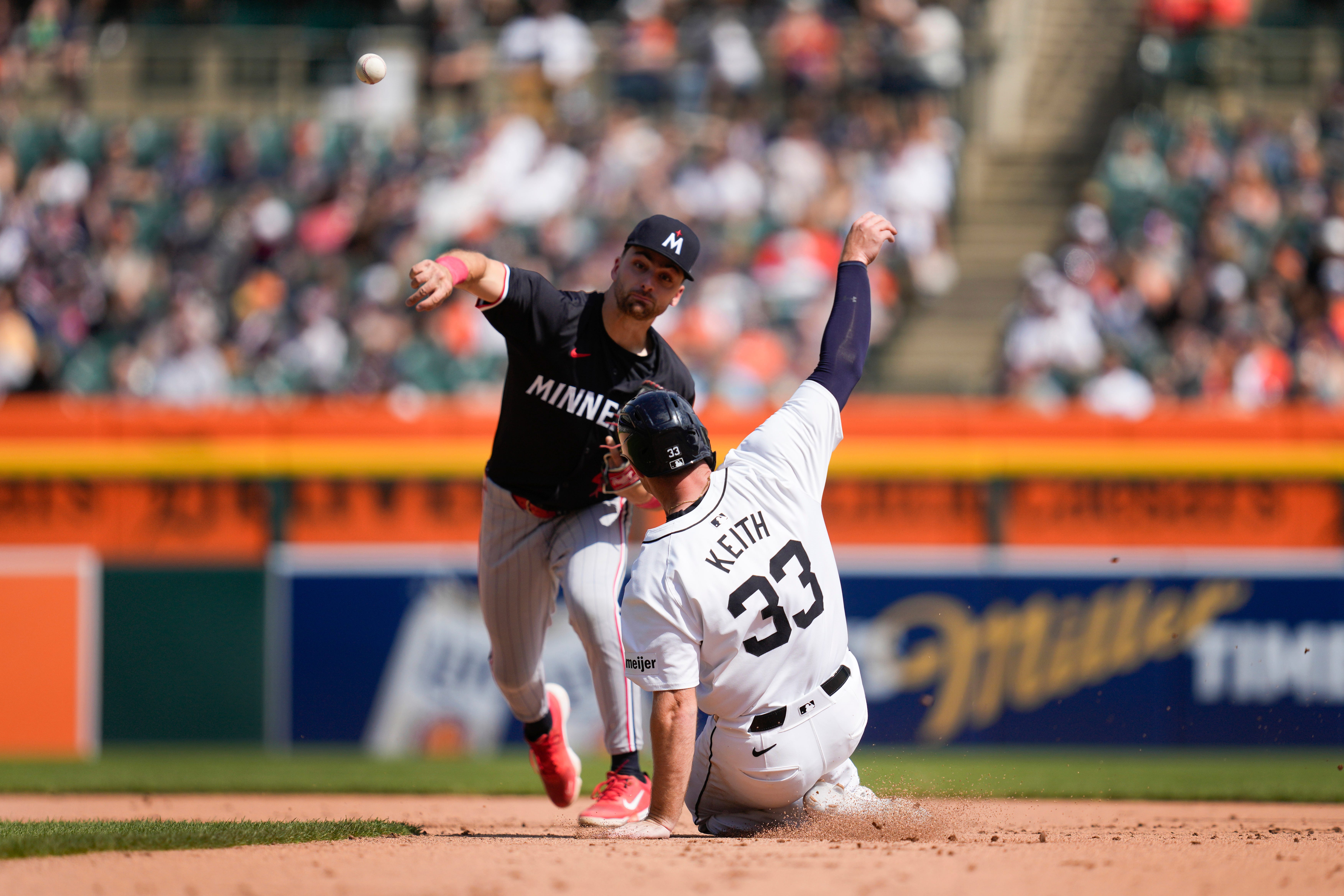 Minnesota Twins second base Edouard Julien (47) throws to first base to complete a double play as Detroit Tigers' Colt Keith (33) slides late into second base in the seventh inning of a baseball game, Sunday, April 14, 2024, in Detroit. (AP Photo/Paul Sancya)