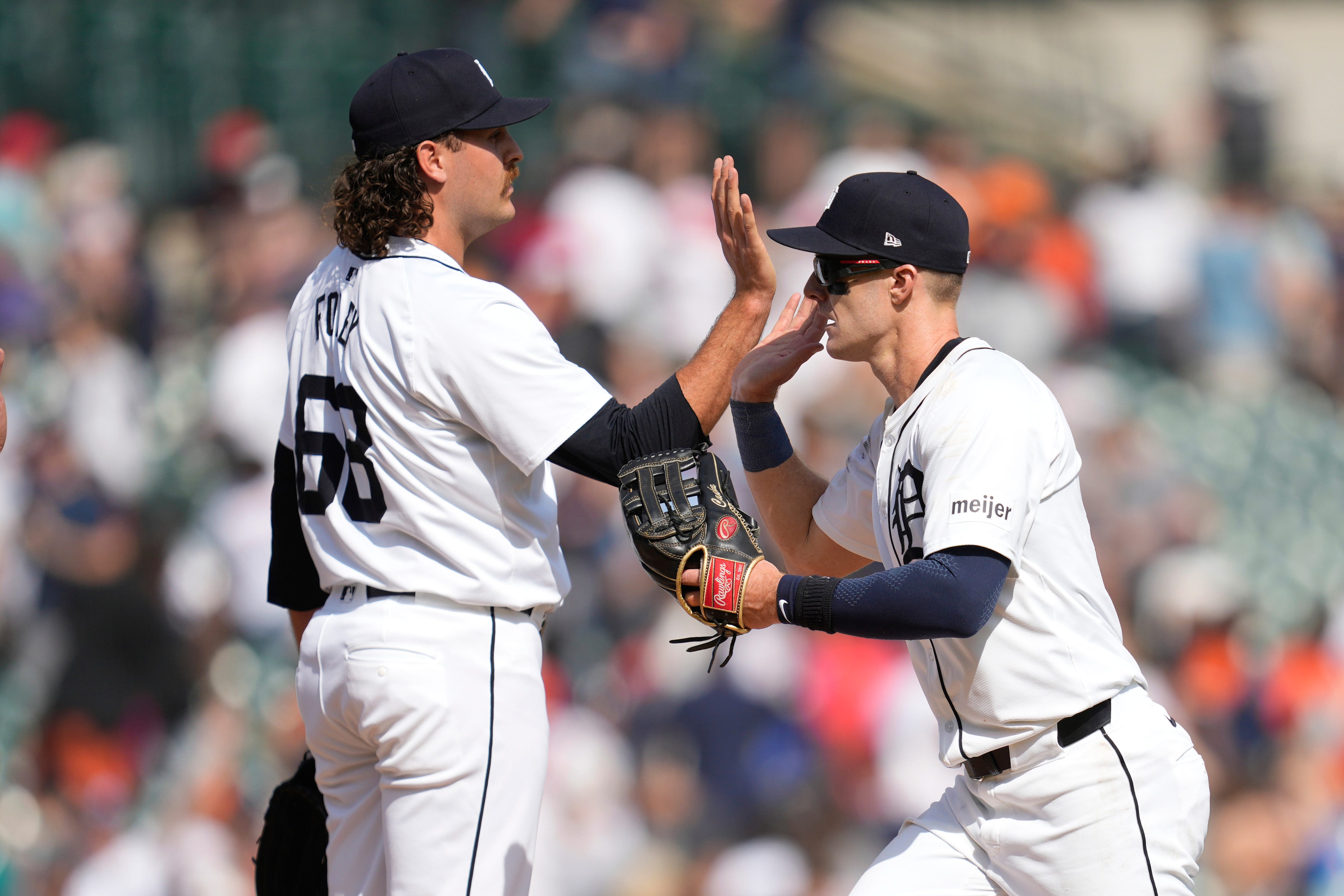 Detroit Tigers pitcher Jason Foley (68) and Mark Canha celebrate after beating the Minnesota Twins after a baseball game, Sunday, April 14, 2024, in Detroit. (AP Photo/Paul Sancya)