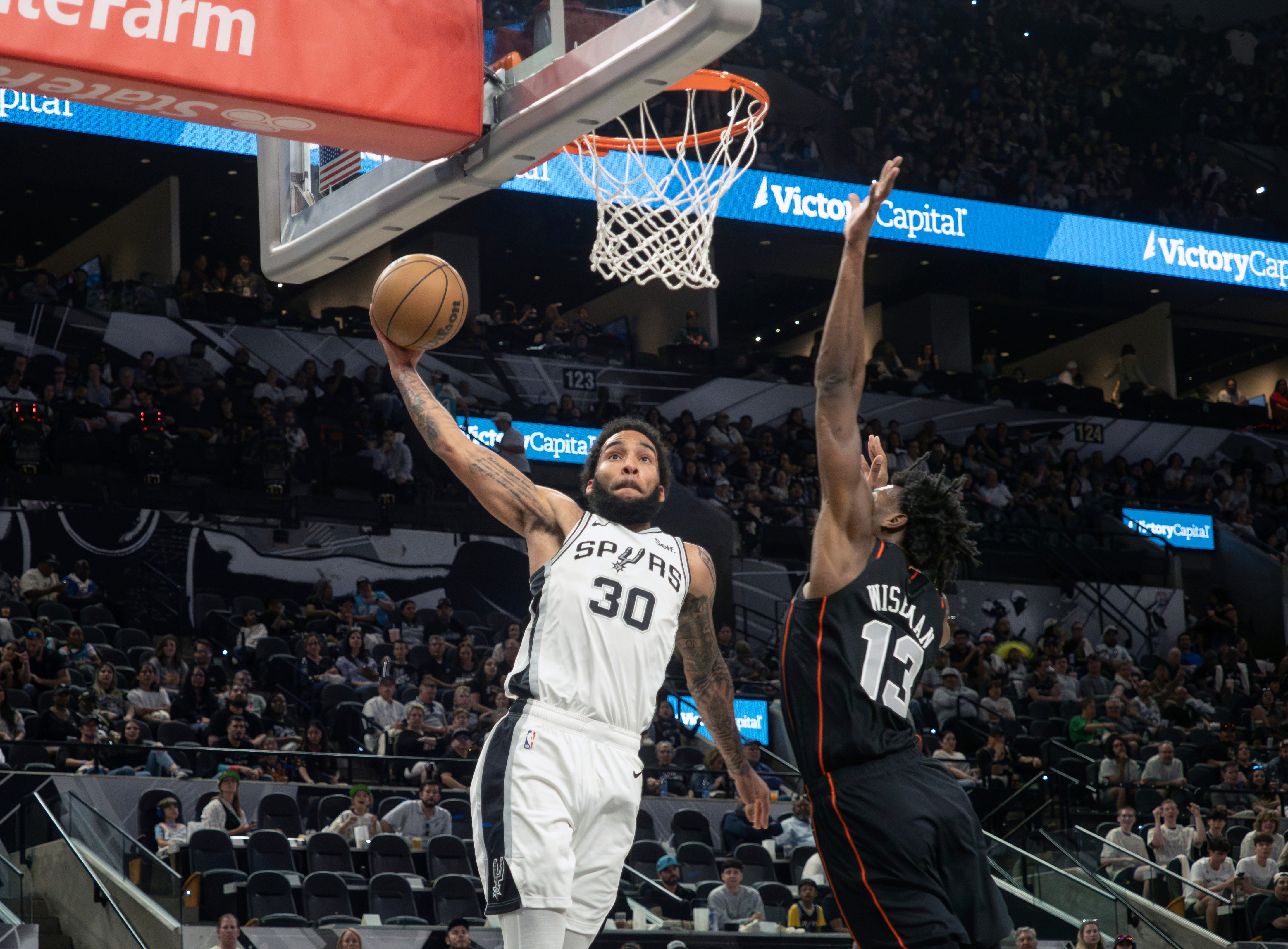 San Antonio Spurs forward Julian Champagnie (30) goes up for a dunk against Detroit center James Wiseman (13) during the first half of an NBA basketball game, Sunday, April 14, 2024, in San Antonio. (AP Photo/Michael Thomas)