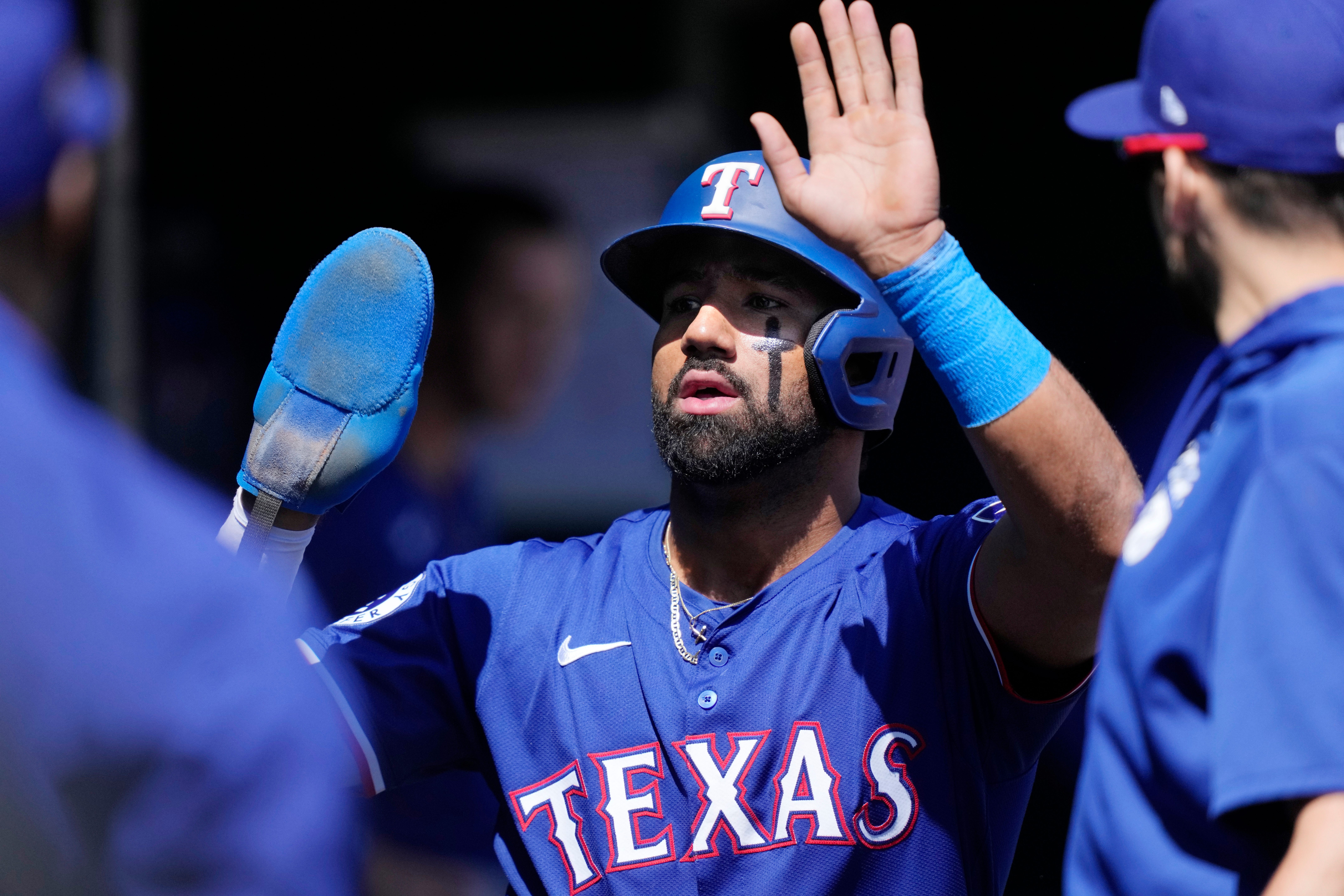 Texas Rangers designated hitter Ezequiel Duran is greeted in the dugout after scoring during the fifth inning.