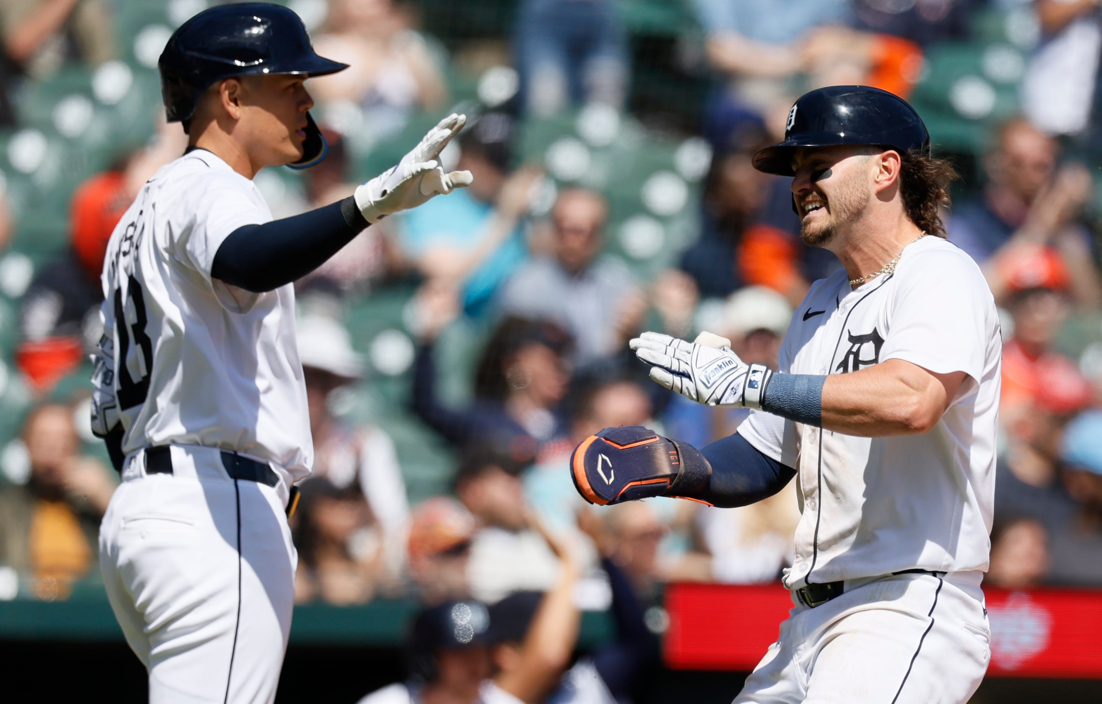 Zach McKinstry #39 of the Detroit Tigers celebrates with Gio Urshela #13 after scoring against the Texas Rangers during the sixth inning.