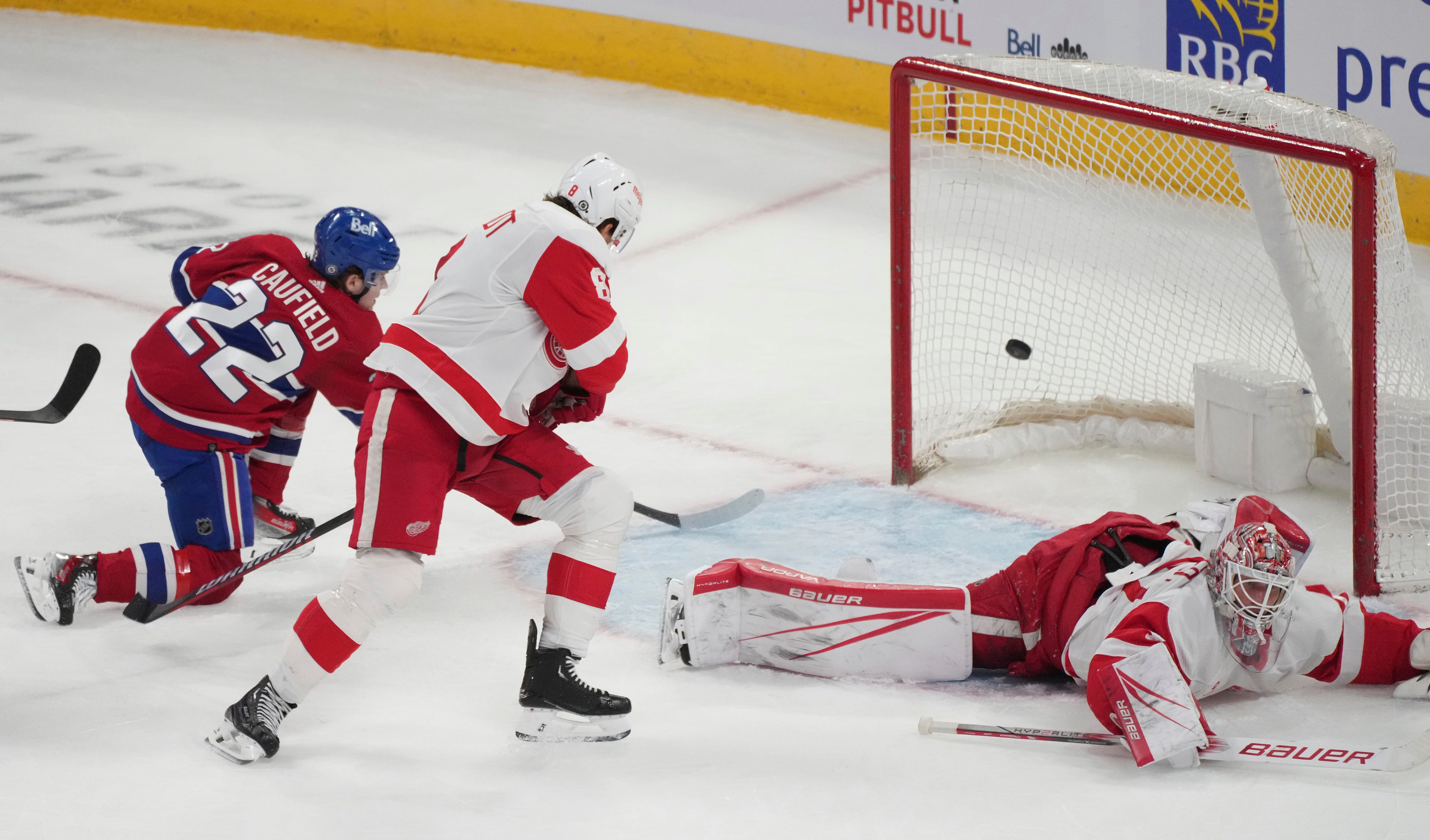 Montreal Canadiens' Cole Caufield (22) scores on Detroit Red Wings goaltender James Reimer (47) during the second period.