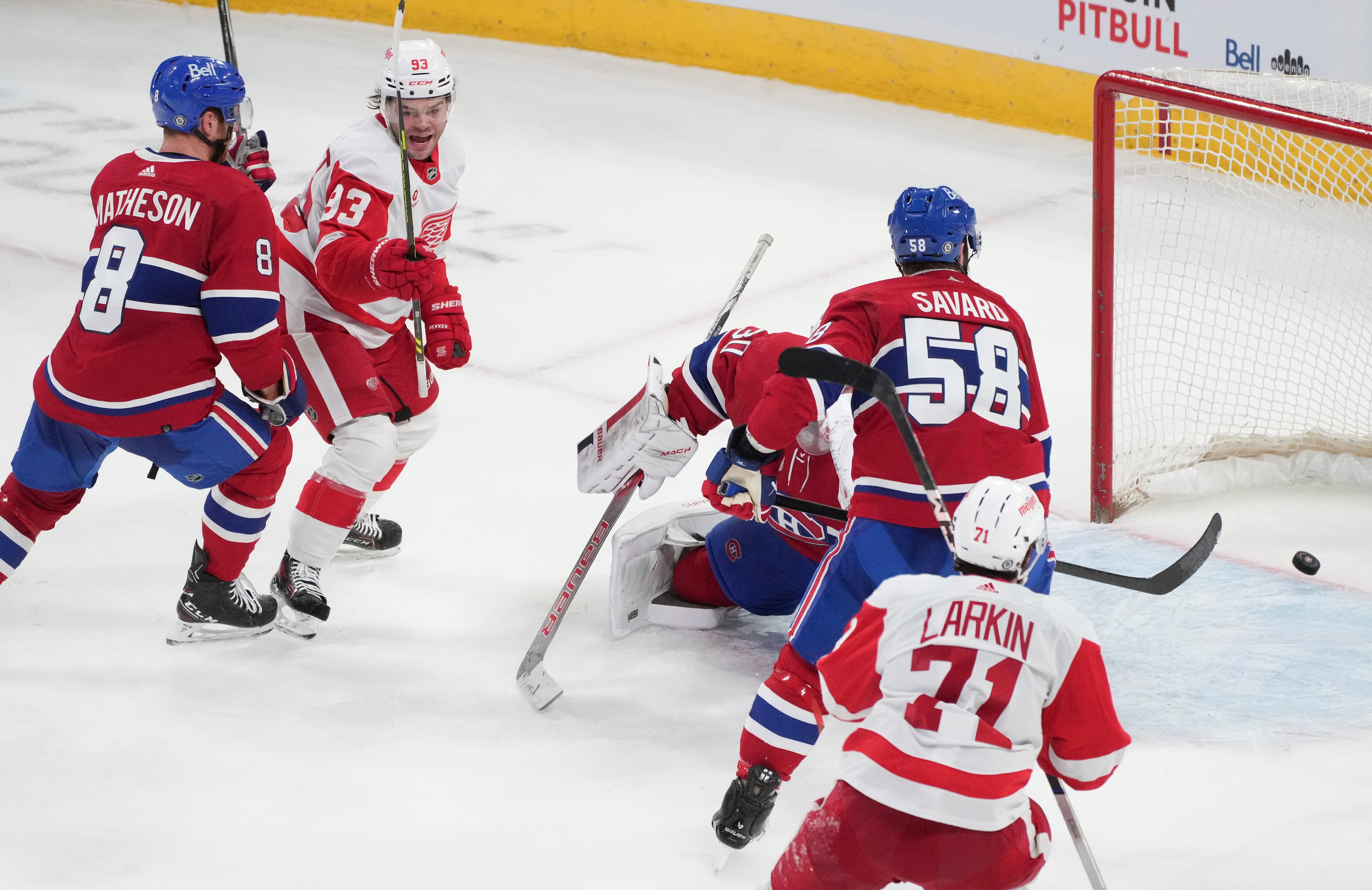 Detroit Red Wings' Alex DeBrincat (93) and Dylan Larkin (71) watch as Montreal Canadiens goaltender Cayden Primeau (30) is scored on by Red Wings' David Perron (not shown) to tie the game during the third period.