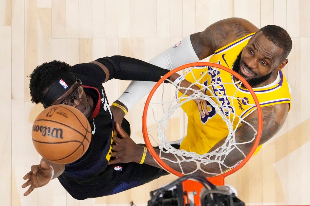 Nuggets guard Reggie Jackson (7) and Lakers forward LeBron James (23) eye the ball during the second half in Game 2 of the first-round playoff series on Monday in Denver.