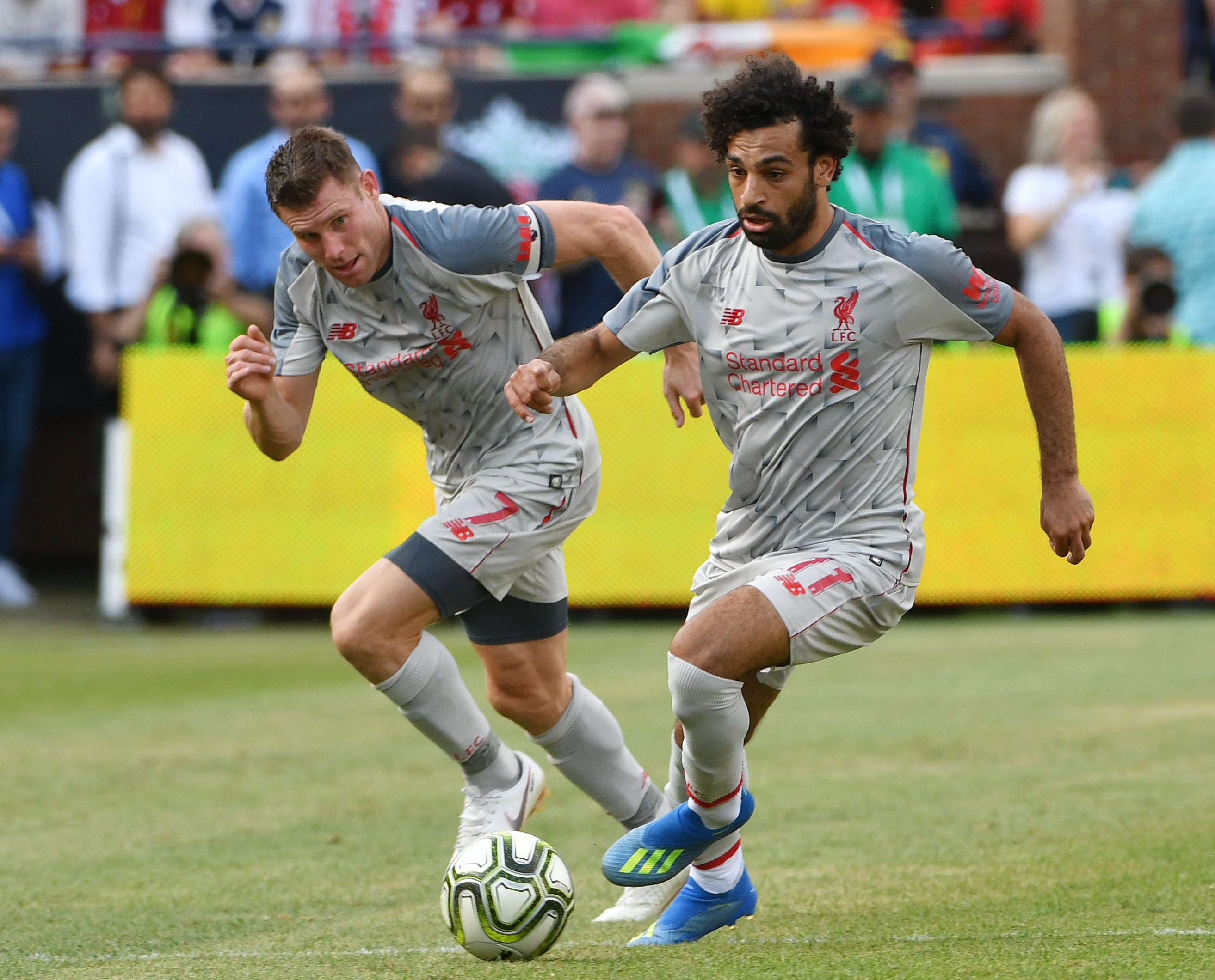 Liverpool's James Milner and Mohamed Salah bring the ball up field in the first half.