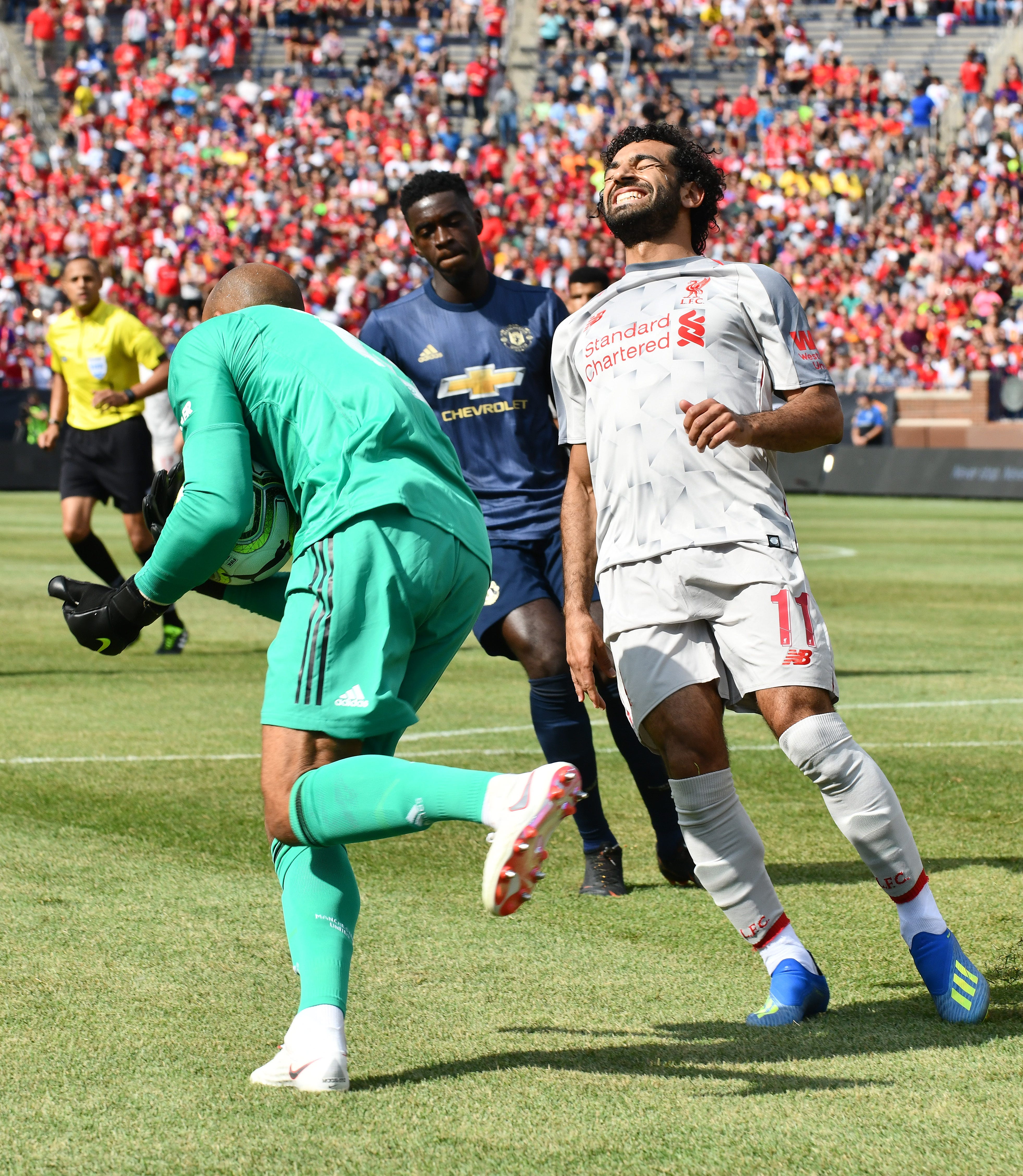 Liverpool's Mohamed Salah grimaces as Manchester goalie Lee Grant is able to scoop up a ball in front of the net before Salah could get a foot on it in the first half.