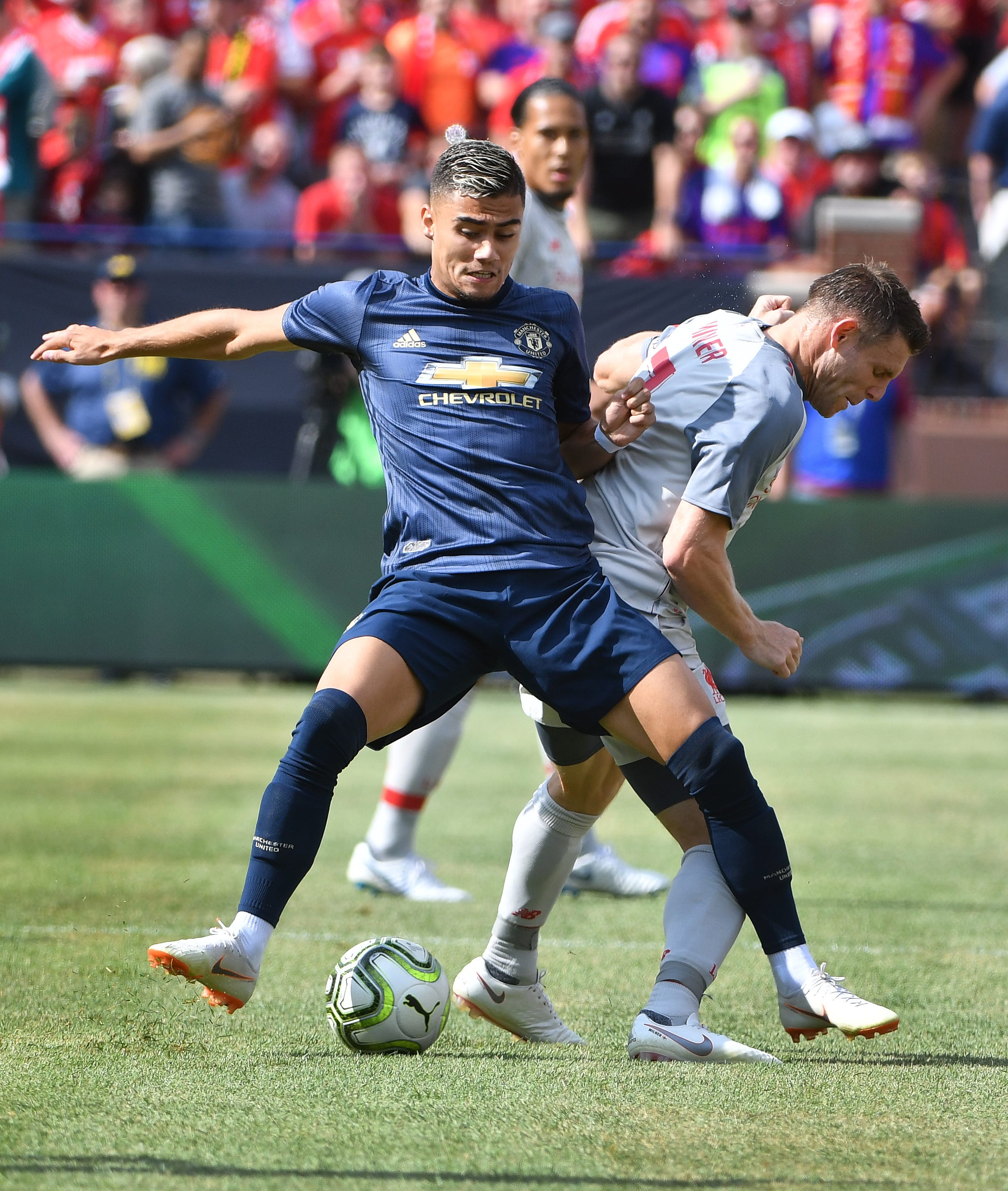 Manchester's Andreas Pereira and Liverpool's James Milner battle for the ball in the first half.