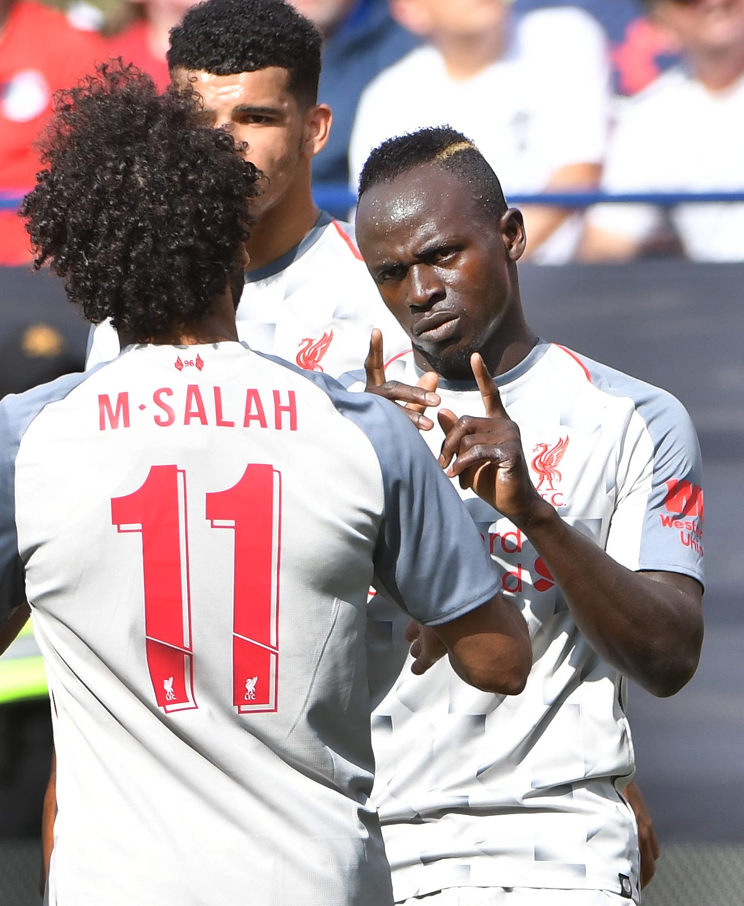 Liverpool's Sadio Mane points out teammate Mohamed Salah after putting in a penalty shot after Salah was kicked in the face by Manchester in the first half.