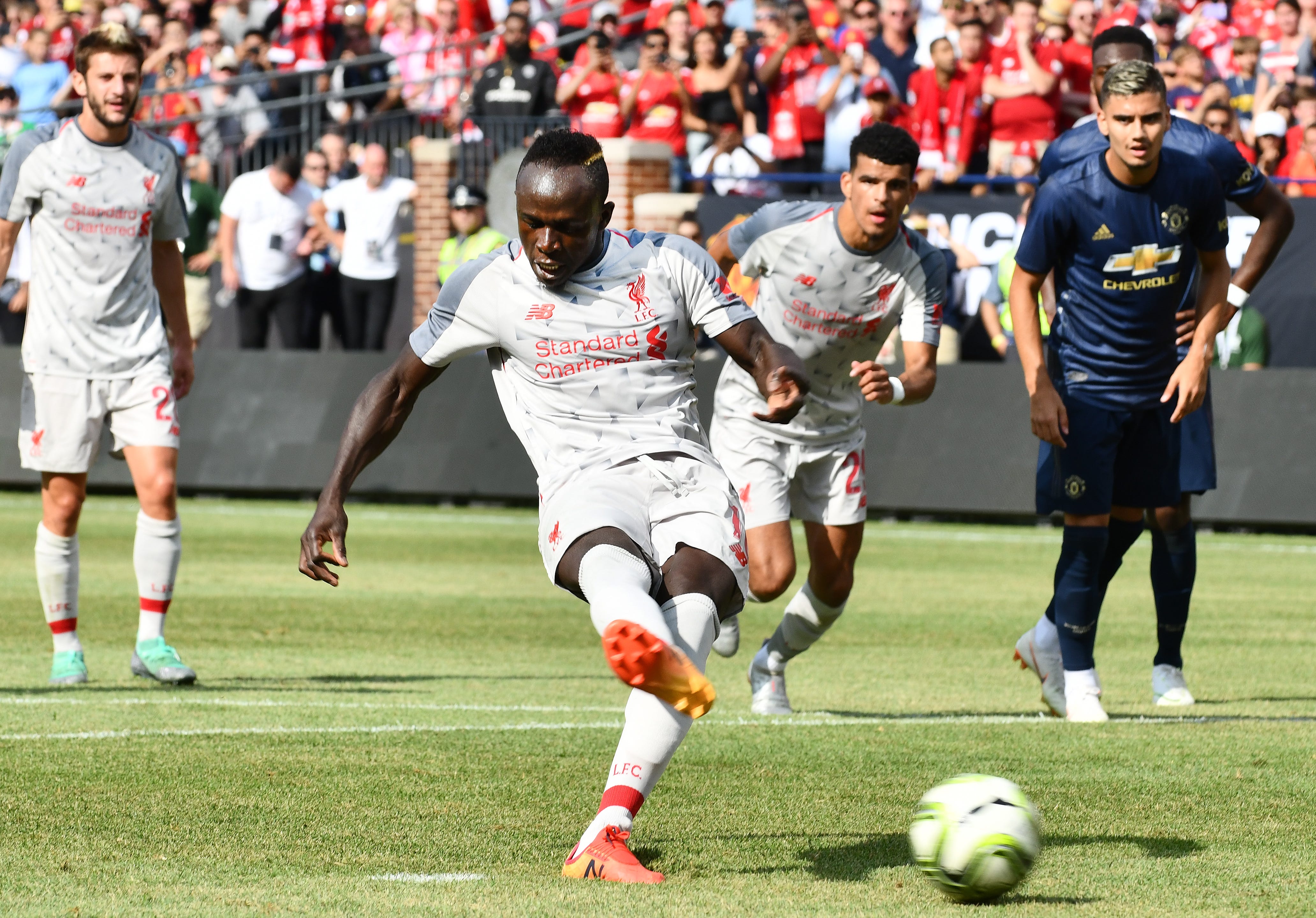 Liverpool's Sadio Mane puts in a penalty shot for the first goal of the game in the first half.