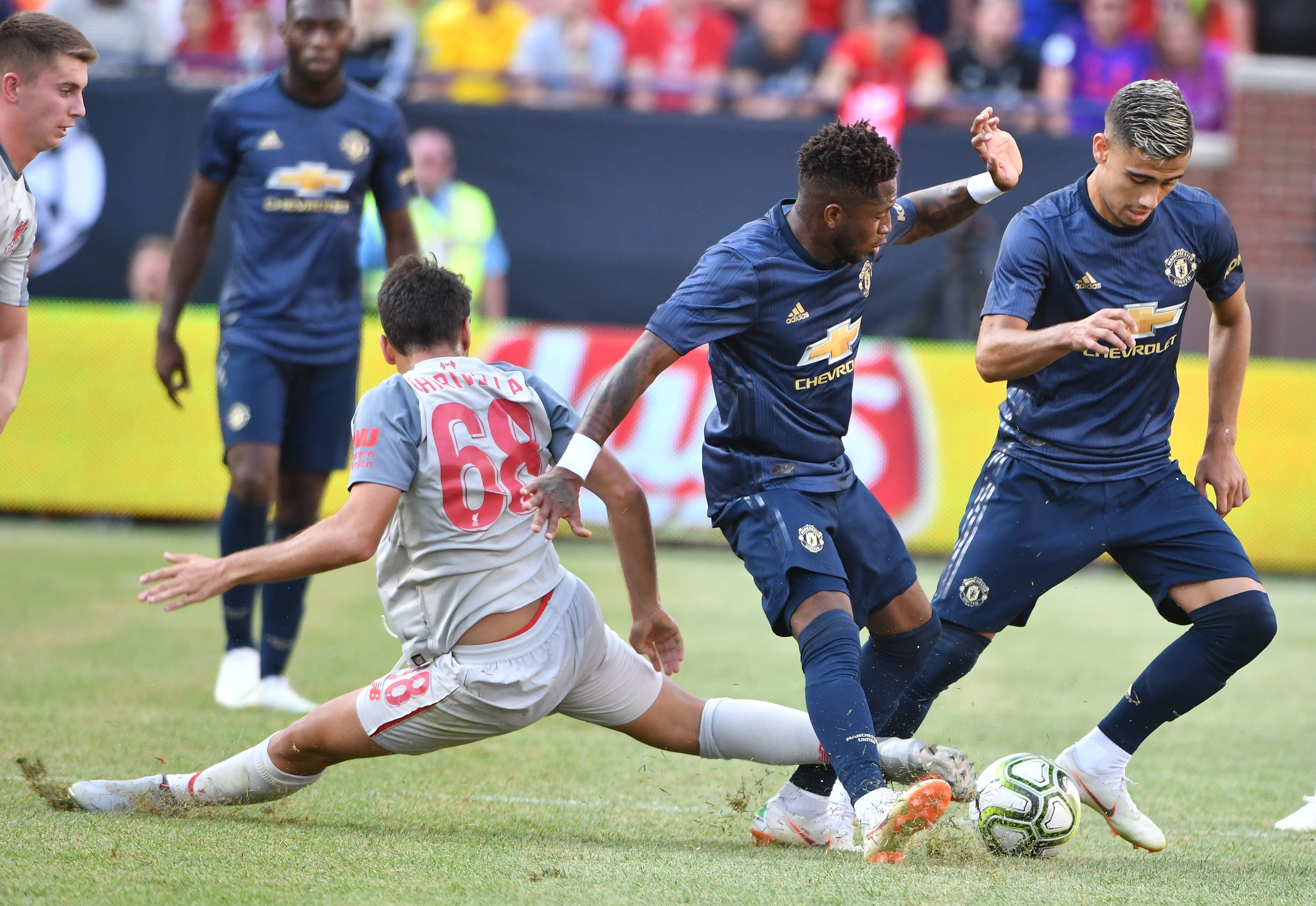 Liverpool's Pedro Chirivella defends against Manchester's Fred and Andreas Pereira in the second half.