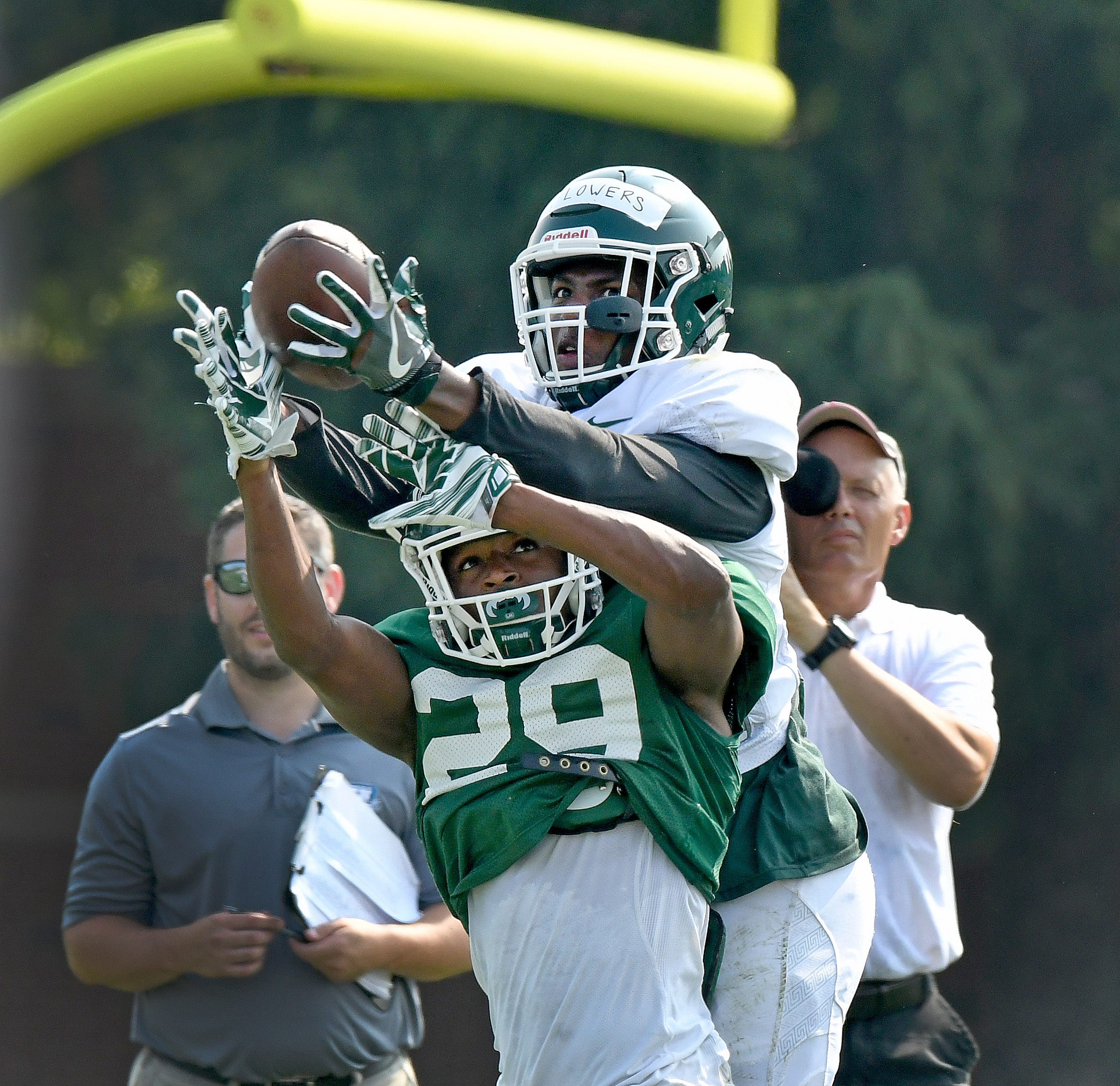 Michigan State receiver Emmanuel Flowers catches the ball over the top of teammate Shakur Brown during a morning practice session Tuesday, Aug. 14, 2018, at MSU's football practice facility in East Lansing.