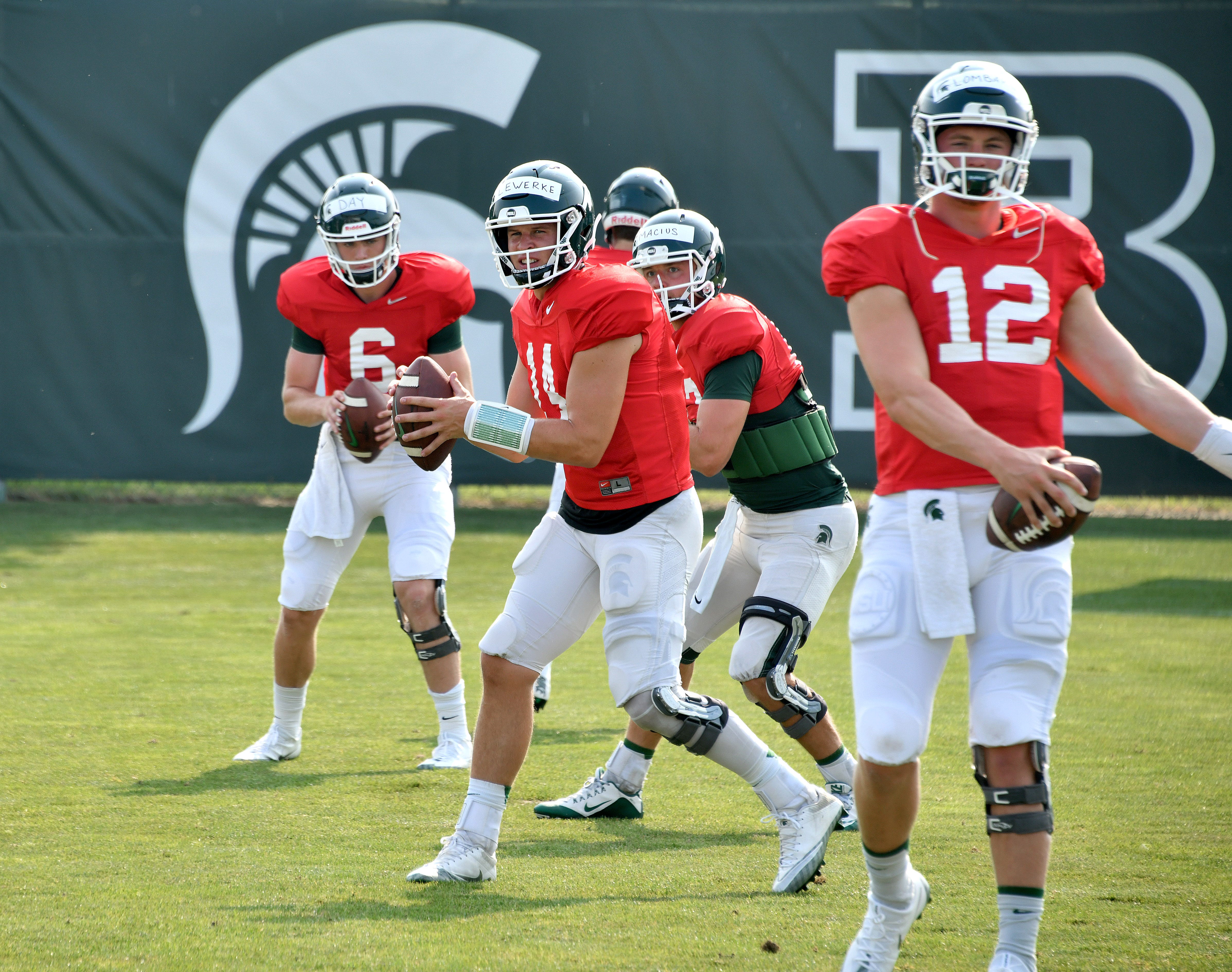The Michigan State quarterbacks take snaps at the start of Tuesday's practice.