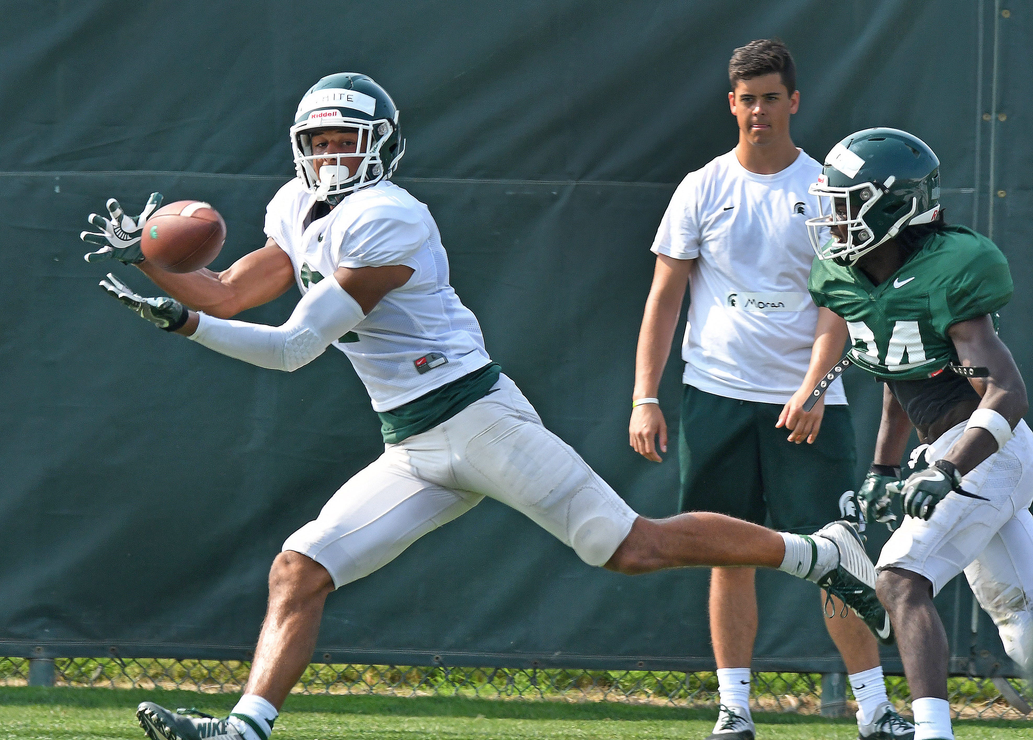 Michigan State receiver Cody White (left) gets out in front of Tre Person in the end zone and catches a touchdown pass.