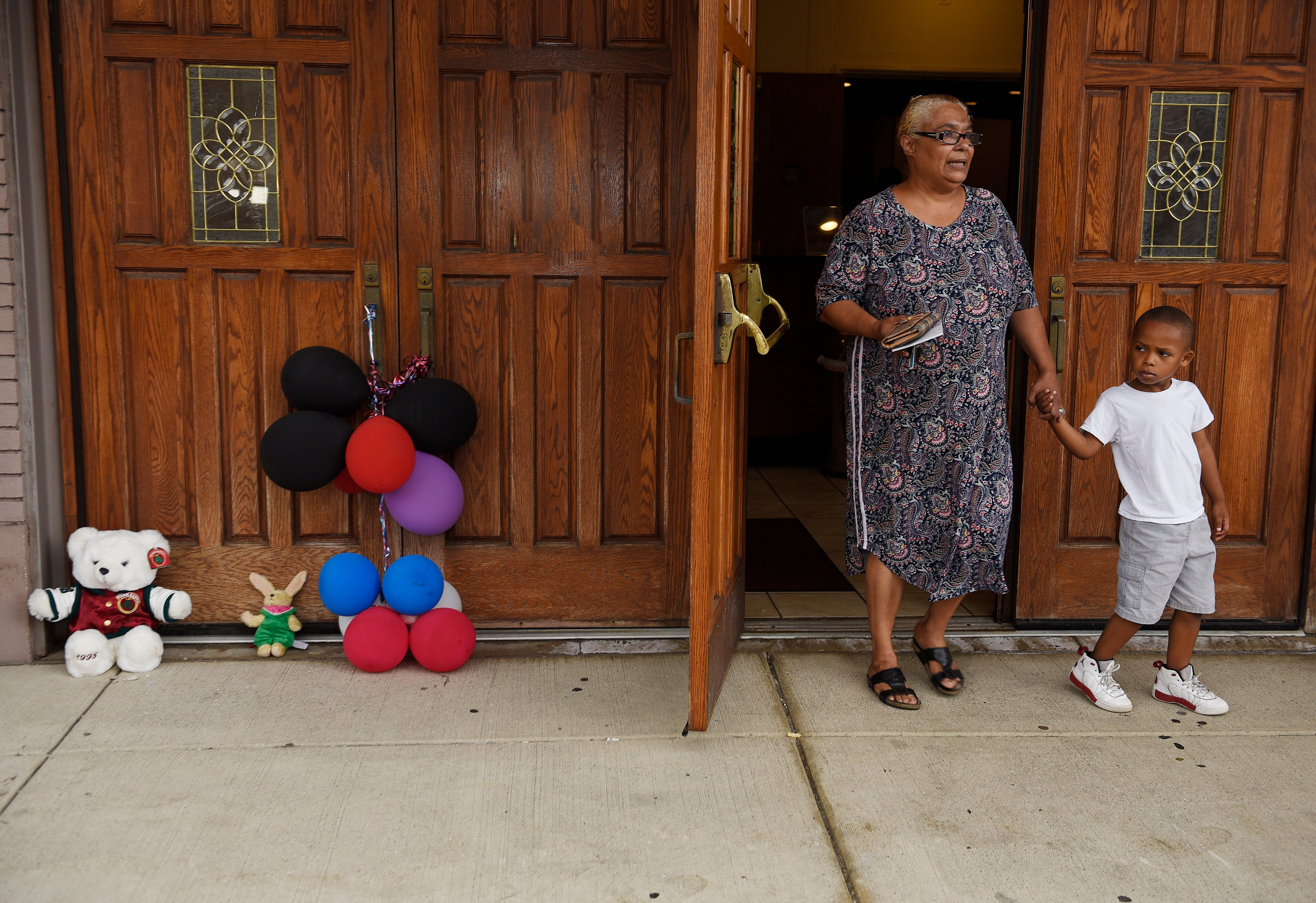 Shelia Laughlin, 58, of Detroit leaves New Bethel Baptist Church with her grandson, Khailon Turner, 5, after dropping off an obituary card for the late Aretha Franklin on Thursday, Aug. 16, 2018, in Detroit.