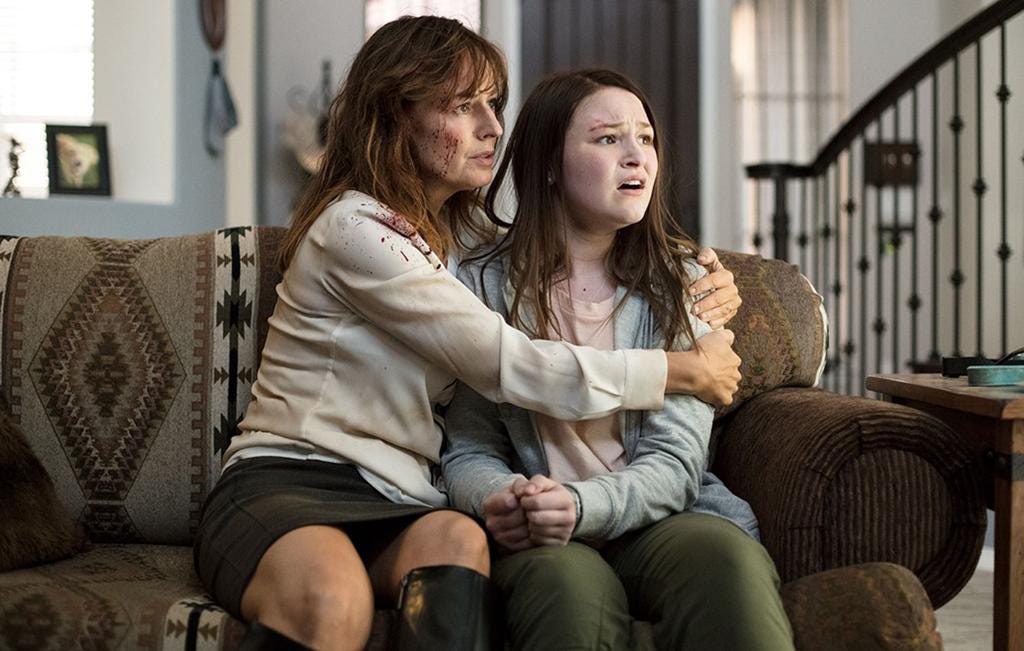 A blood-spattered Rosemarie DeWitt, left, comforts a petrified Lolli Sorenson in the comedic thriller “Arizona.”