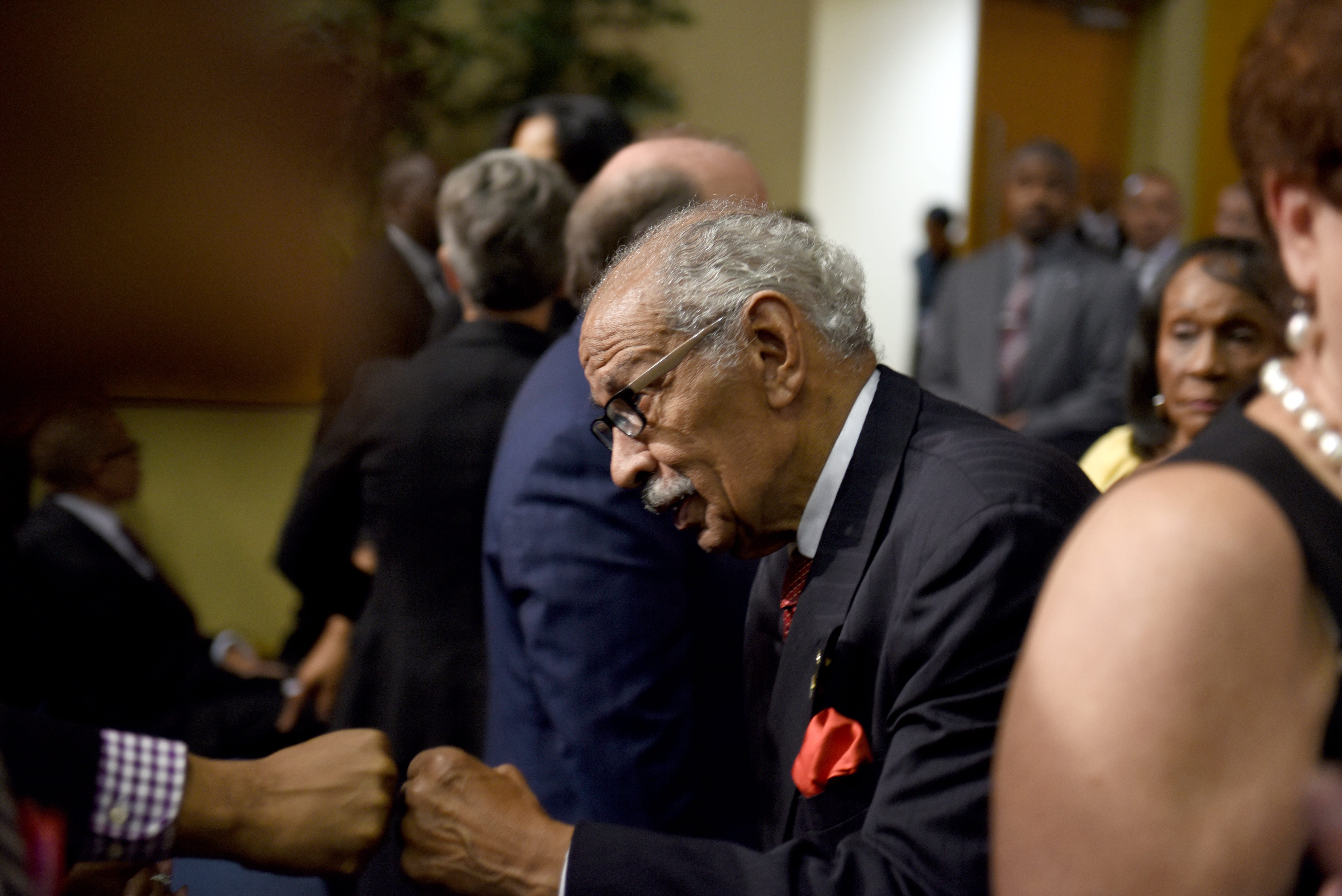 Former U.S. Congressman John Conyers gets a fist bump at the Aretha Franklin memorial at Greater Grace Temple.