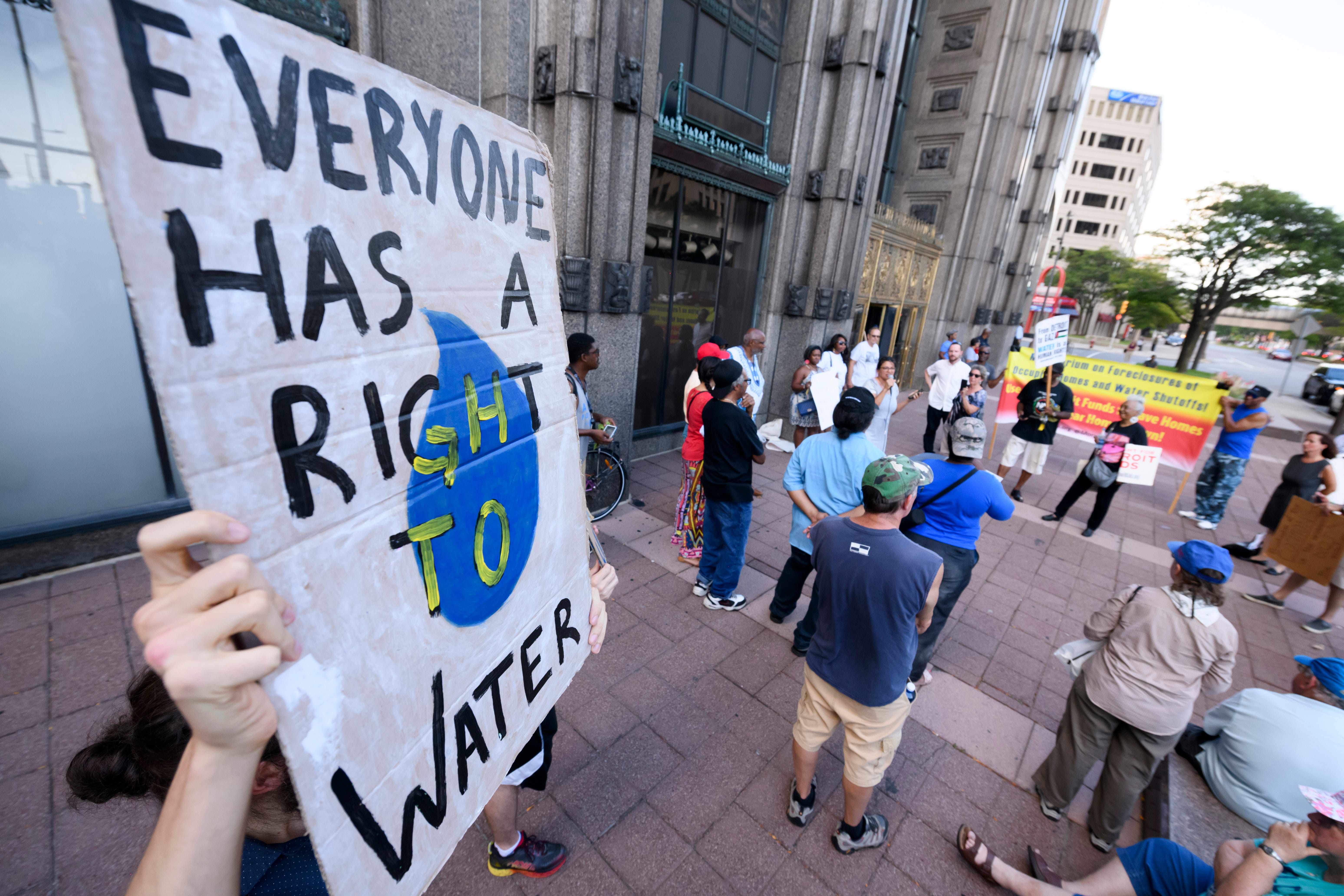 Signs are held during a demonstration and protest demanding safe and clean drinking water for students at Detroit Public Schools, held at the Fisher Building, home of the DPSCD administration office, in Detroit, September 4, 2018.