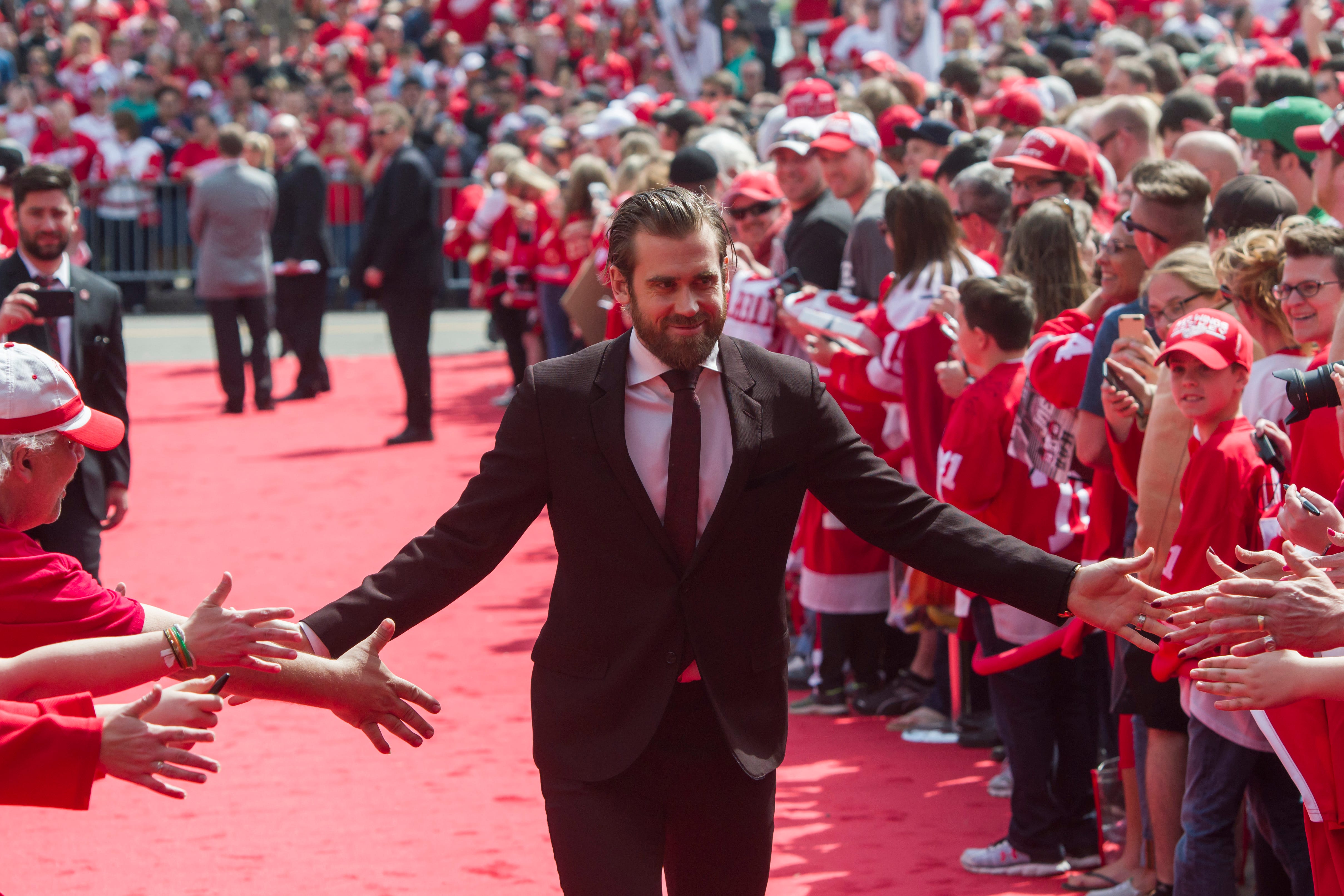 Captain Henrik Zetterberg high-fives the fans while walking down the red carpet before the final game at Joe Louis Arena against the New Jersey Devils April 1, 2017.